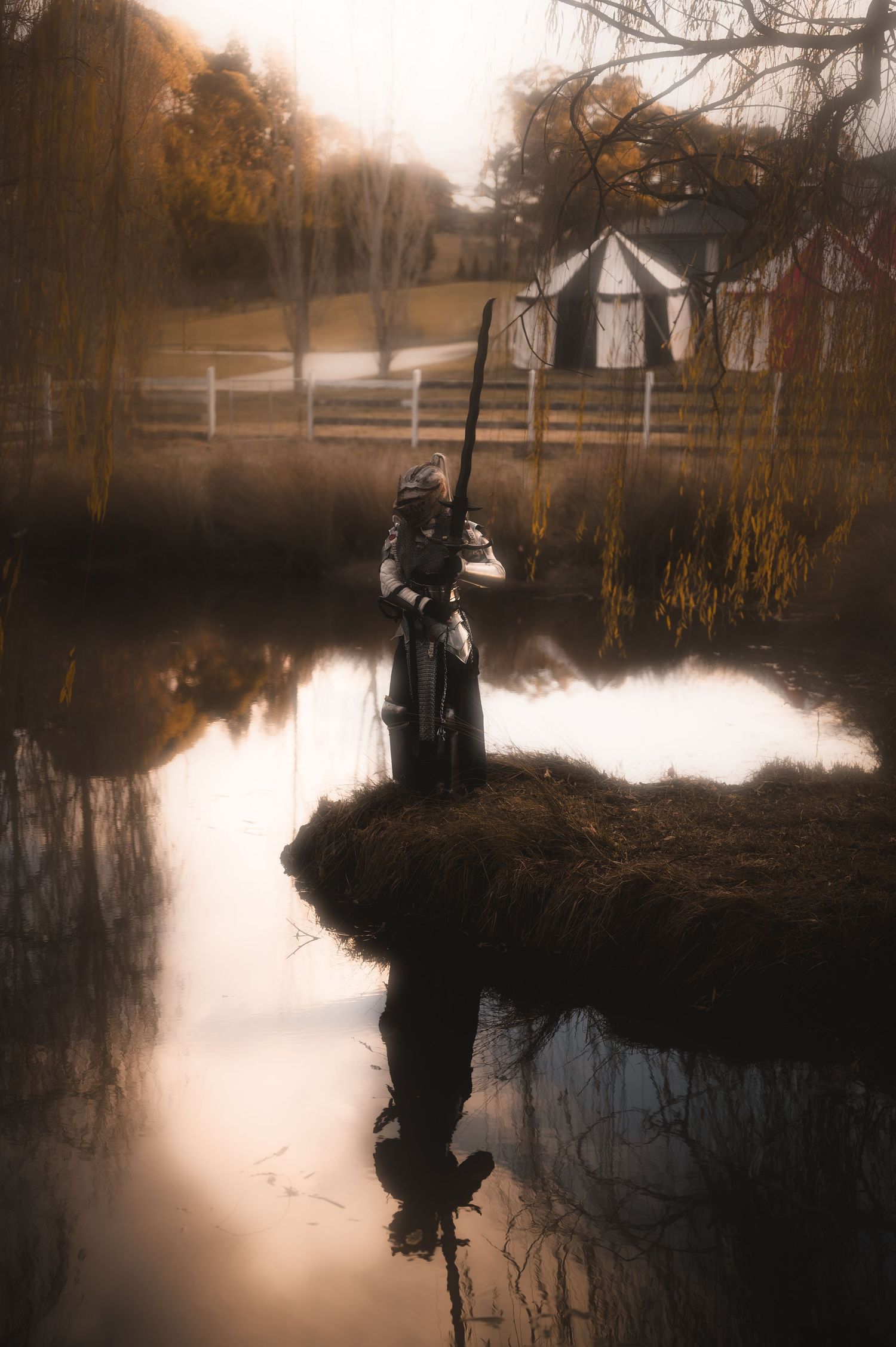 Serene lakeside scene with silhouettes against misty autumn landscape.