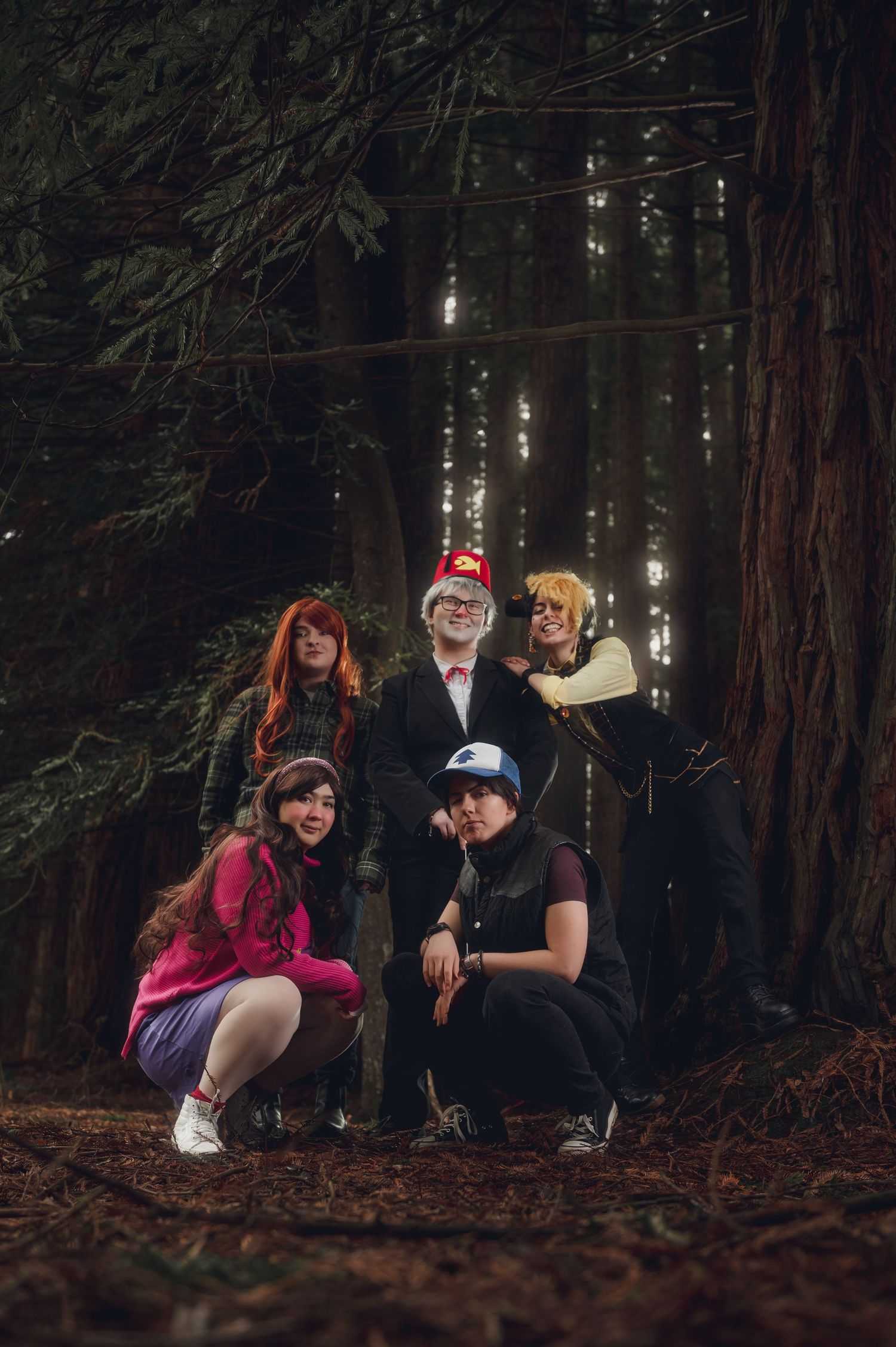 Friends relaxing together on fallen leaves in a misty redwood forest.