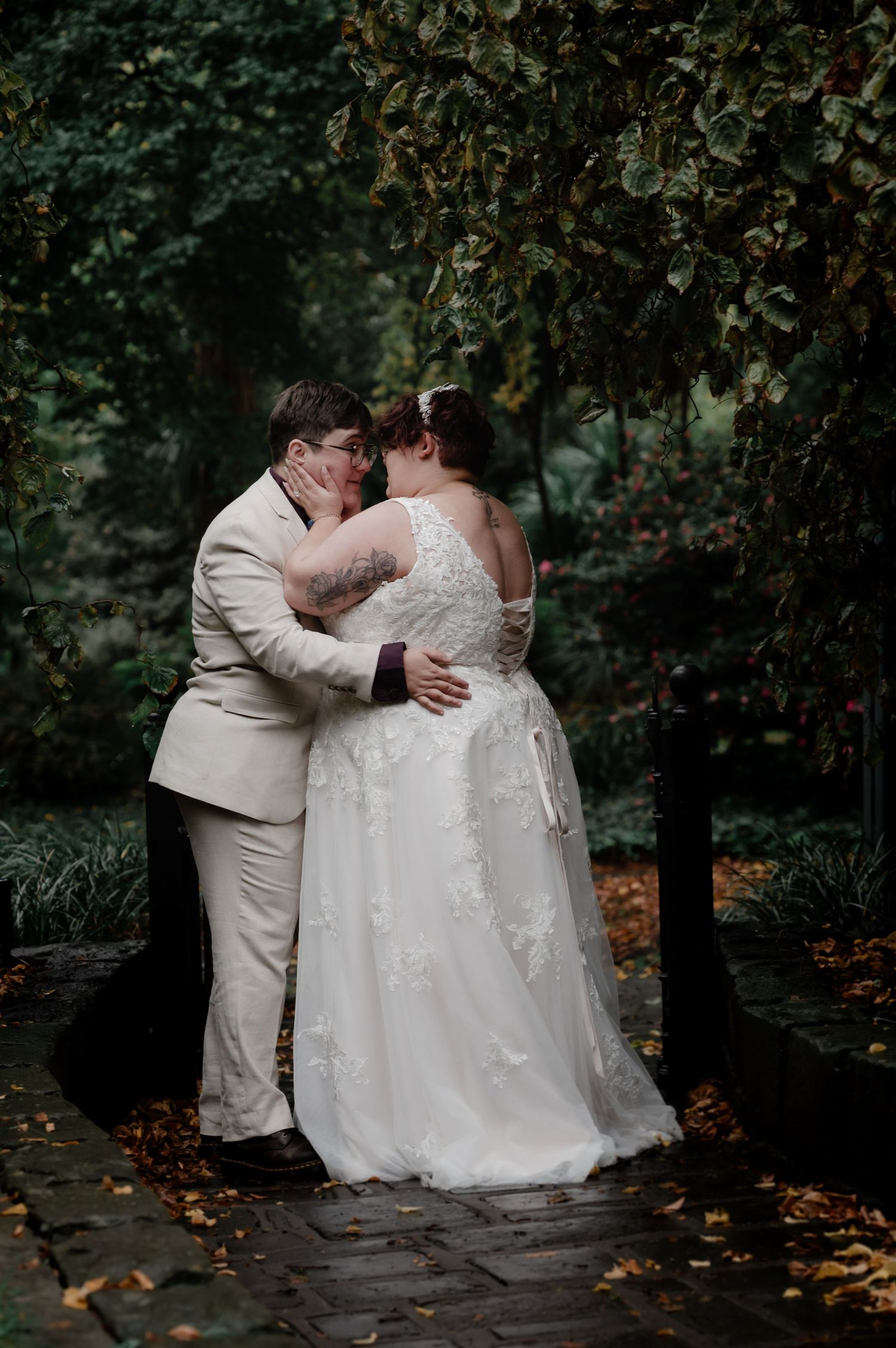 A romantic wedding moment captured in a lush garden setting with fall foliage.