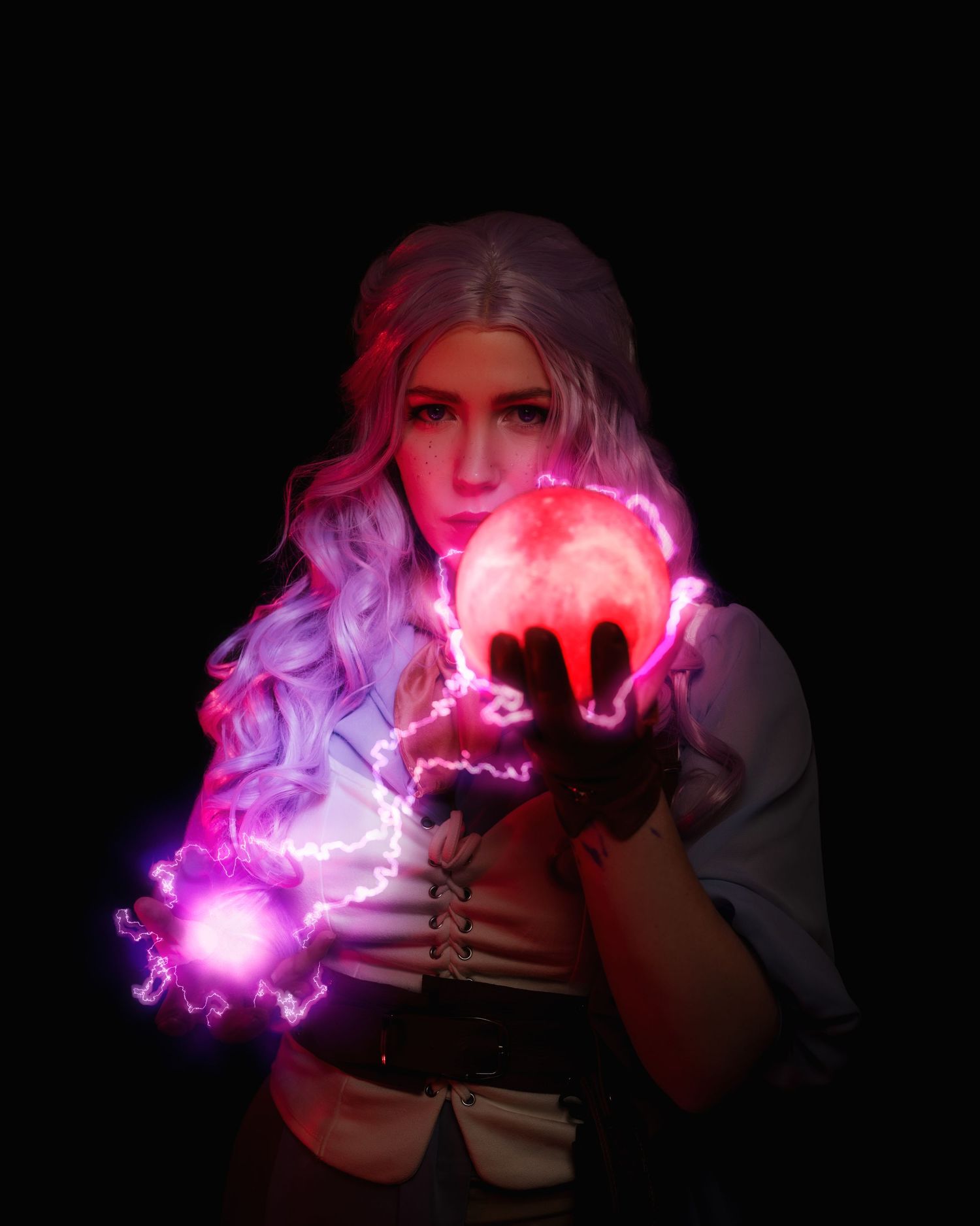 Mystical photography featuring glowing pink and purple magical effects in darkness.