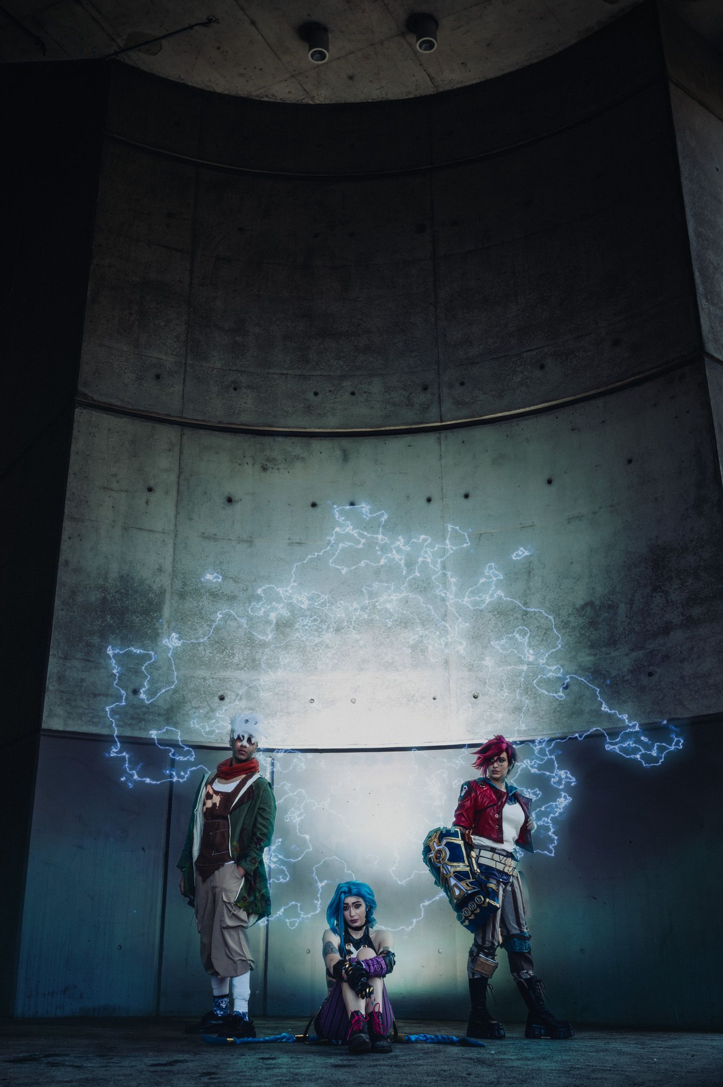 Dramatic cosplay photoshoot with blue electric effects against concrete wall.