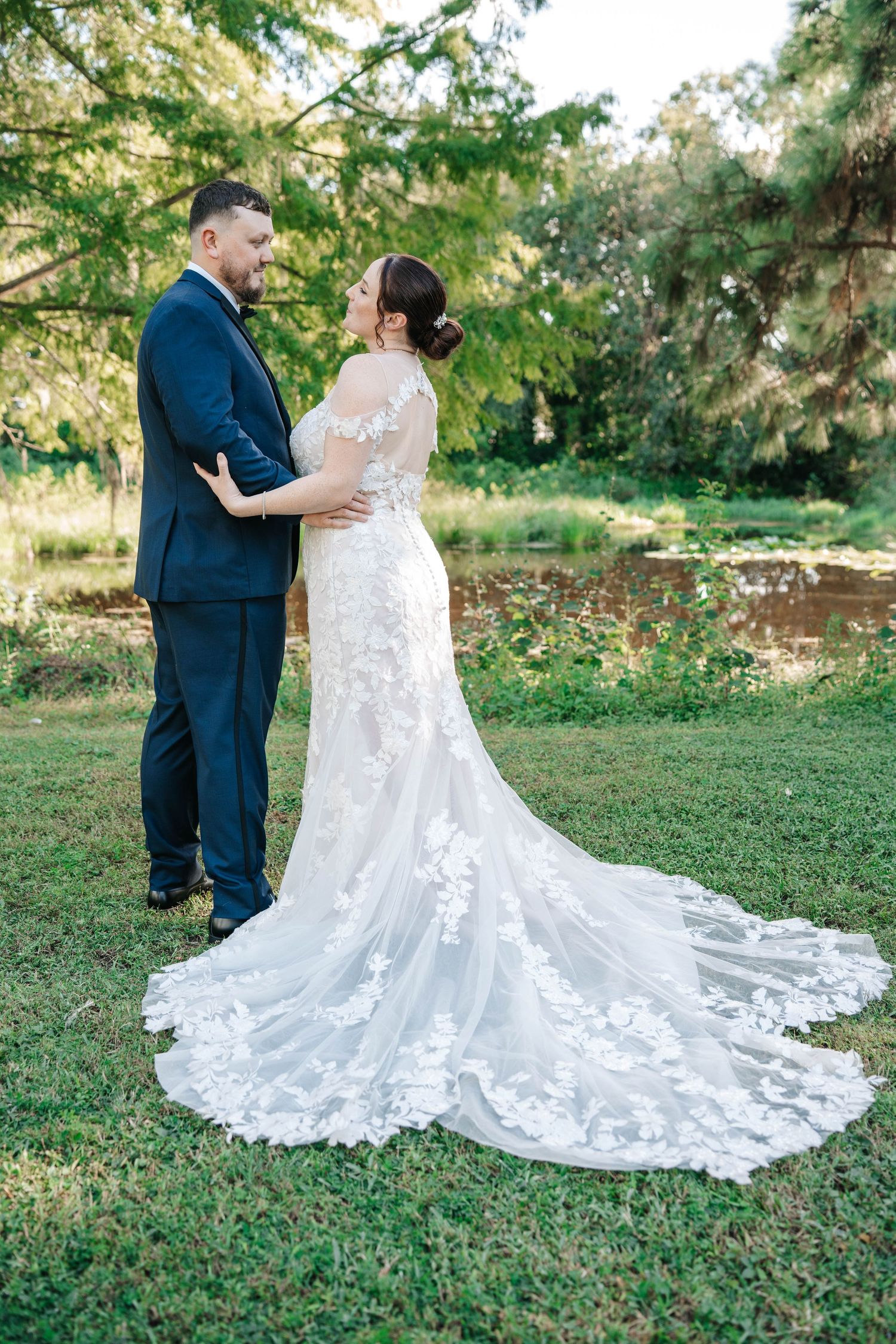 A couple shares an intimate moment outdoors in wedding attire