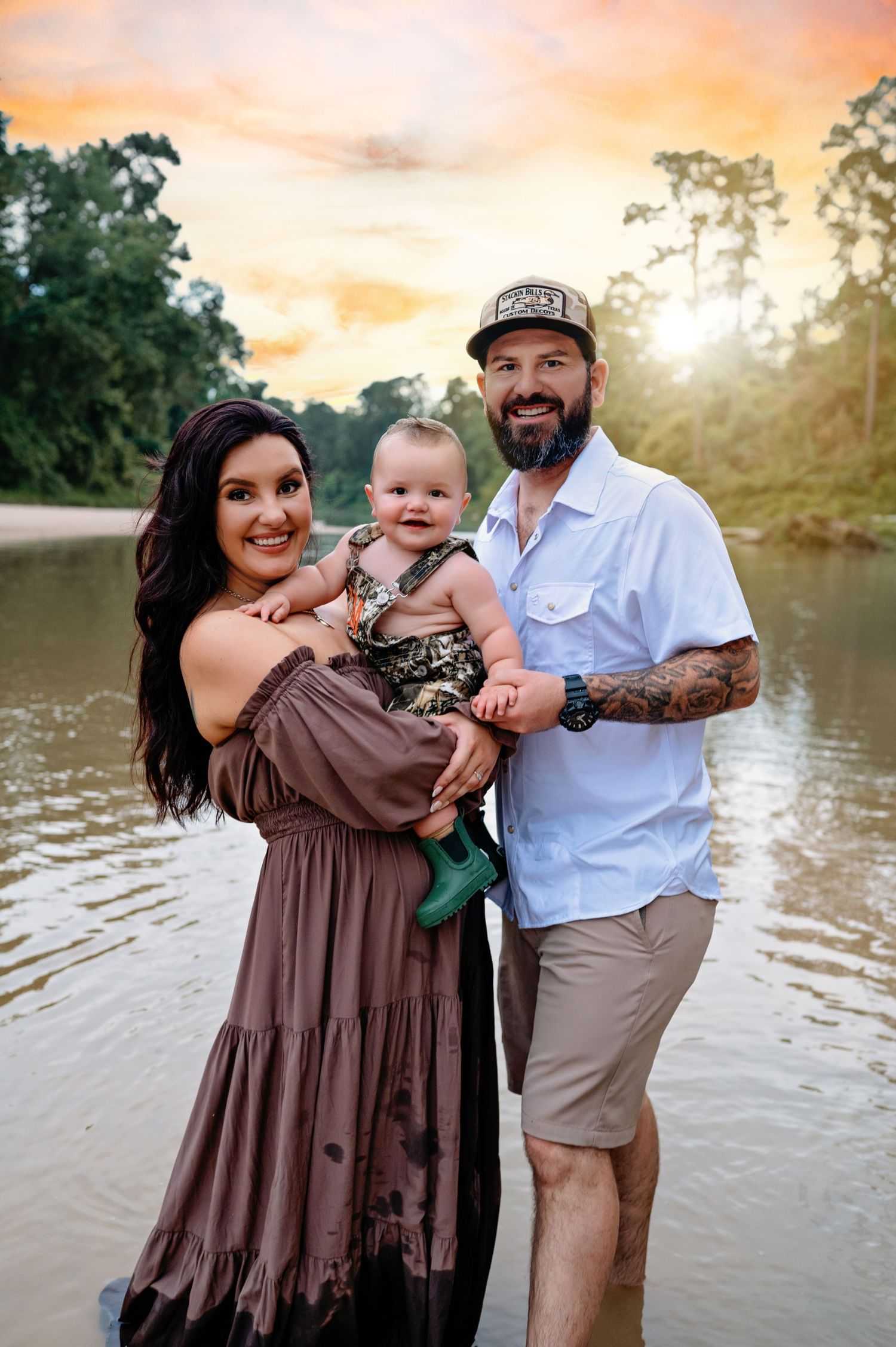 Family enjoying a sunset photo session by a lake in brown and beige outfits with natural golden lighting.