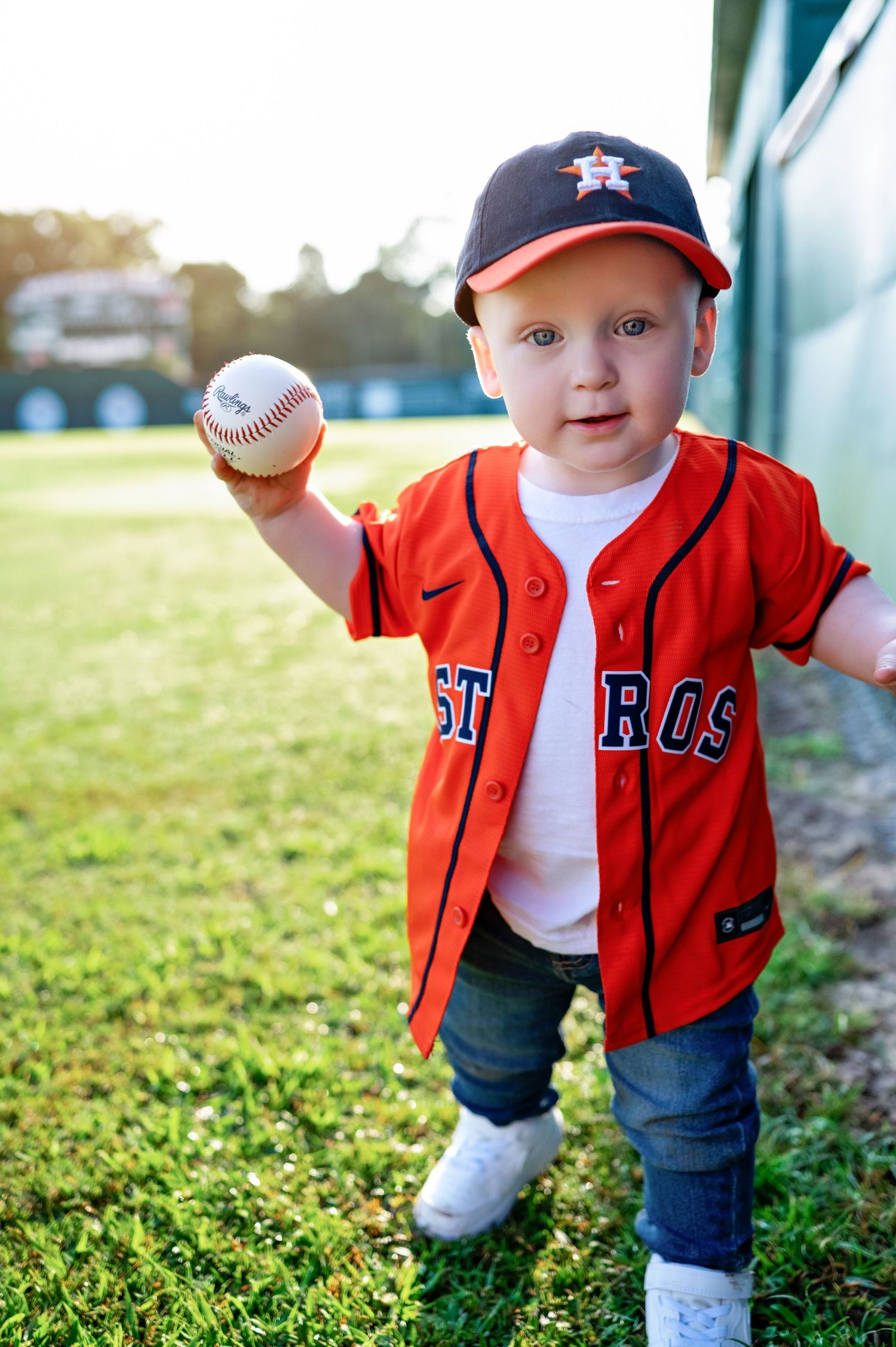 Close-up images showing orange baseball jersey and hat from multiple angles on grass outdoors.