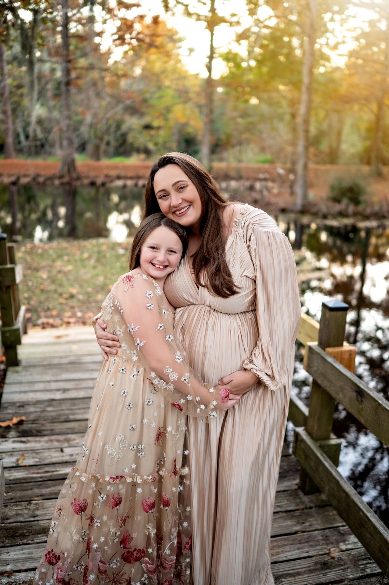 Two people share a joyful moment together on a wooden dock during golden hour in autumn.