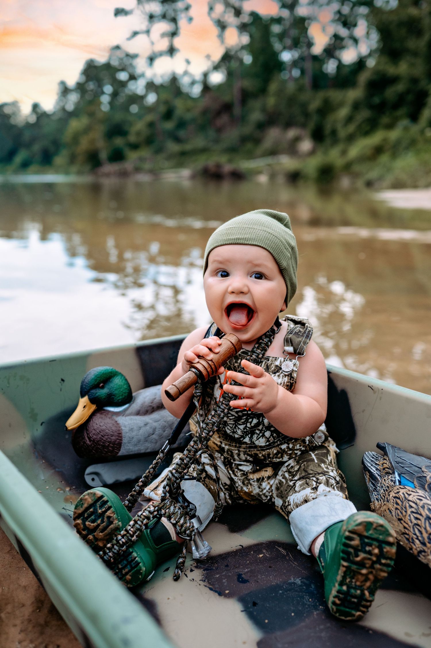 A series of three connected photos showing a baby in camouflage lying in a small boat on the water.