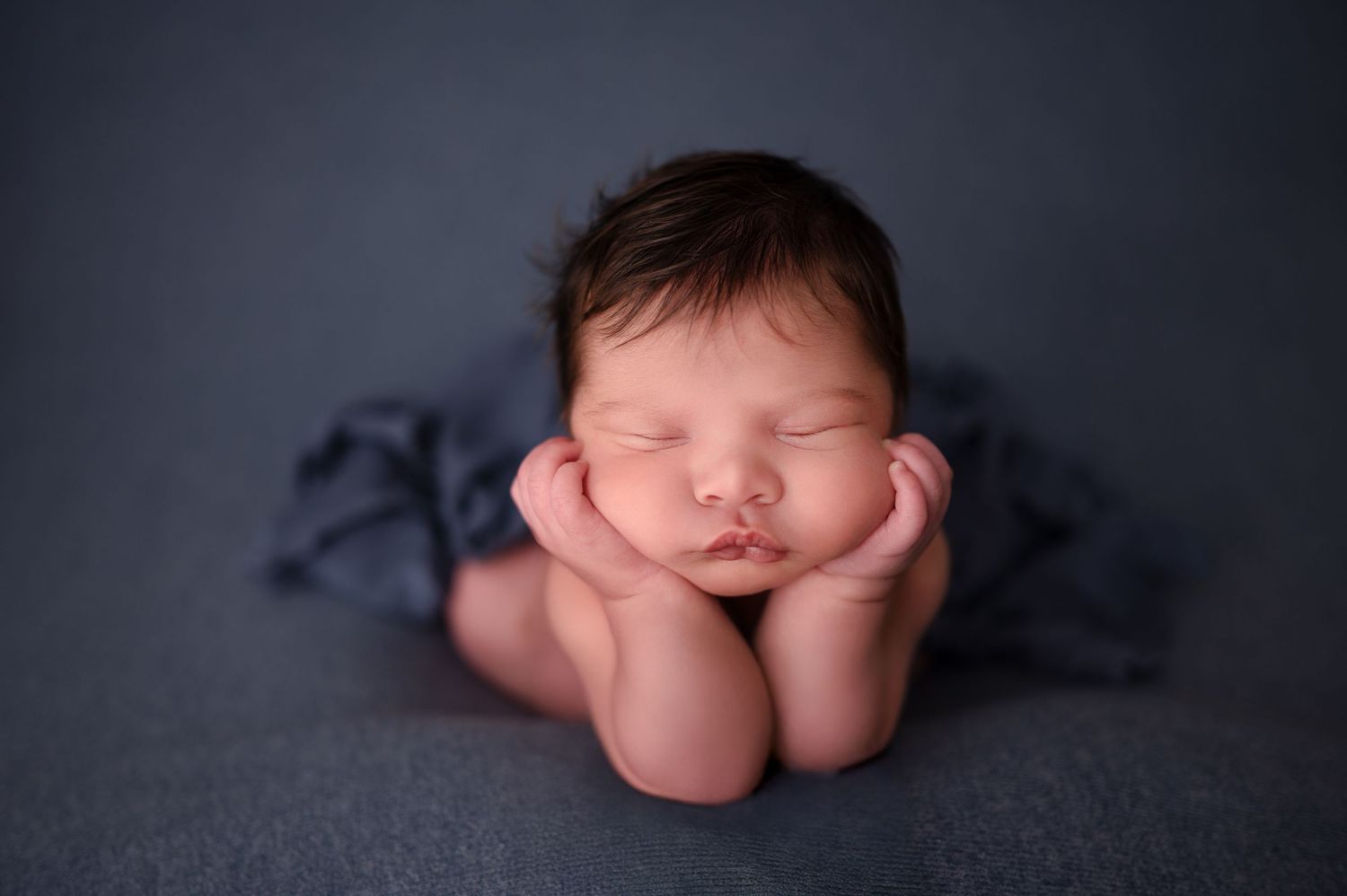 A series of artistic newborn baby portraits showing close-up details against a dark gray background.