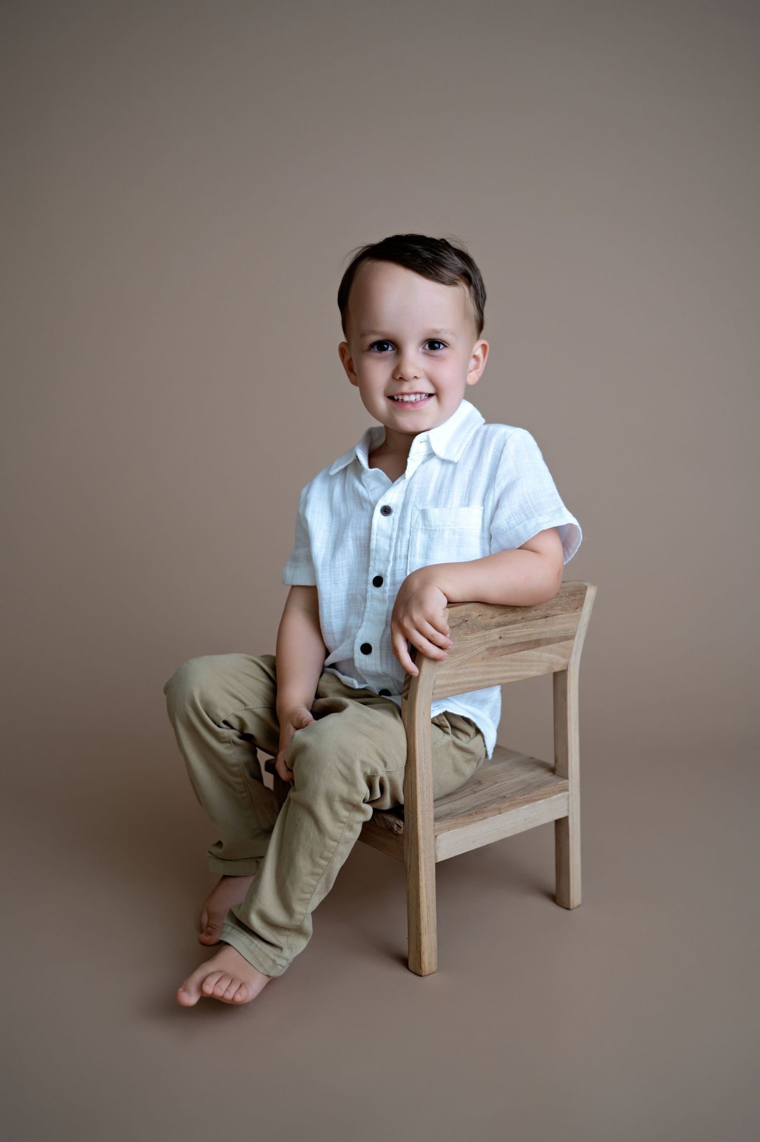 A sequence of candid portraits showing a toddler in khaki pants and white shirt sitting and posing on a wooden bench.