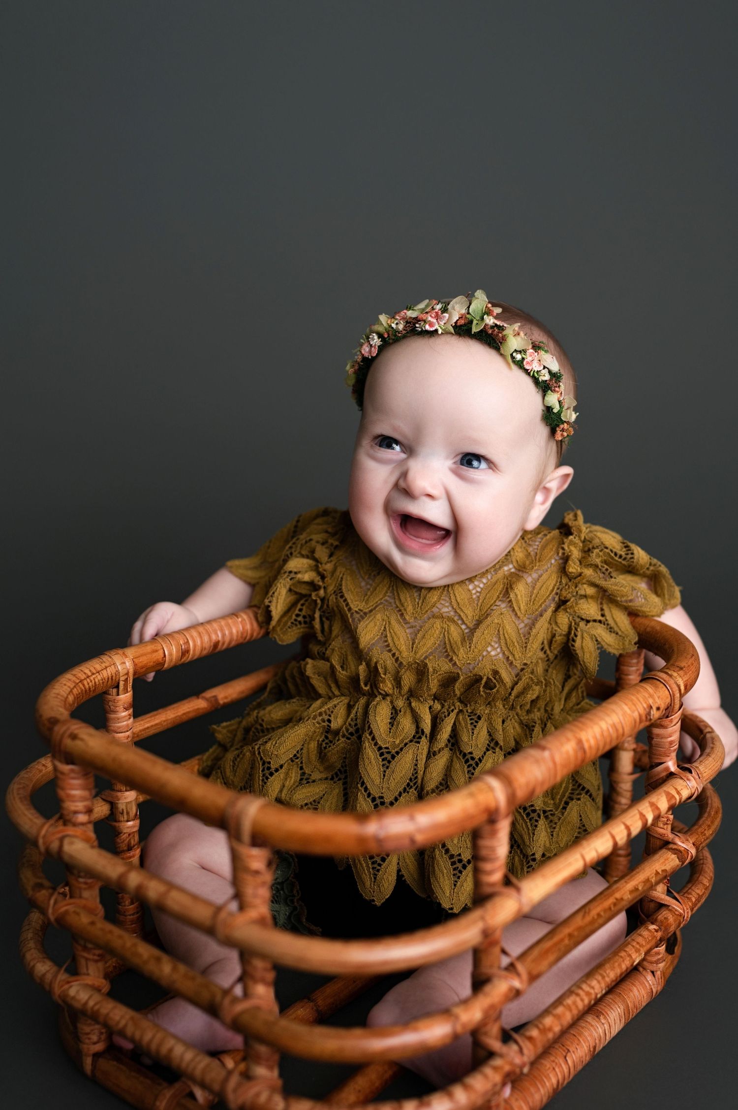 Artistic photo sequence showing a baby in a brown knit outfit posed as a sausage link in pretzel-shaped bread.