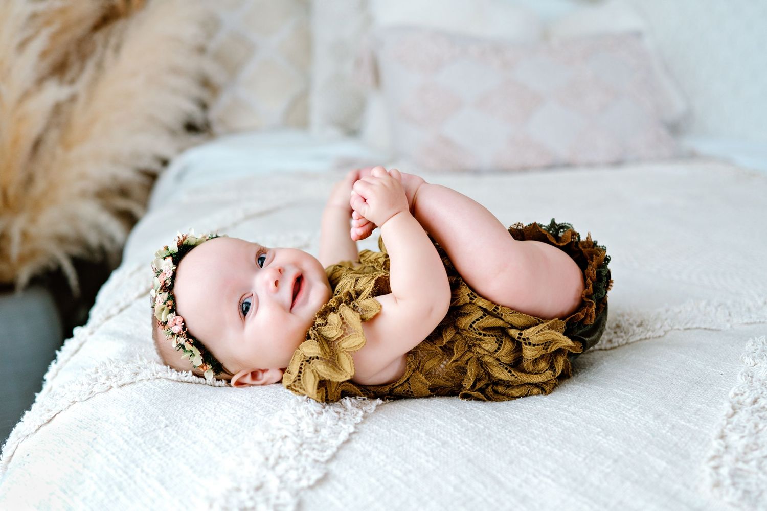 Sequential photos show a small baby lying on a white lace backdrop in different poses capturing sweet moments.