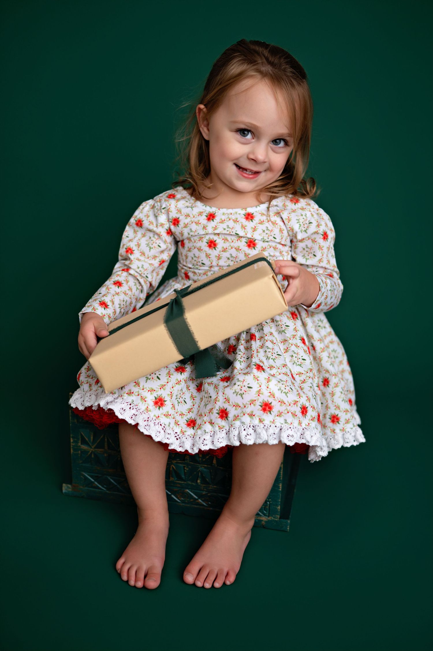 A child in a red and white floral dress holds a book against a dark green background in a series of shots.