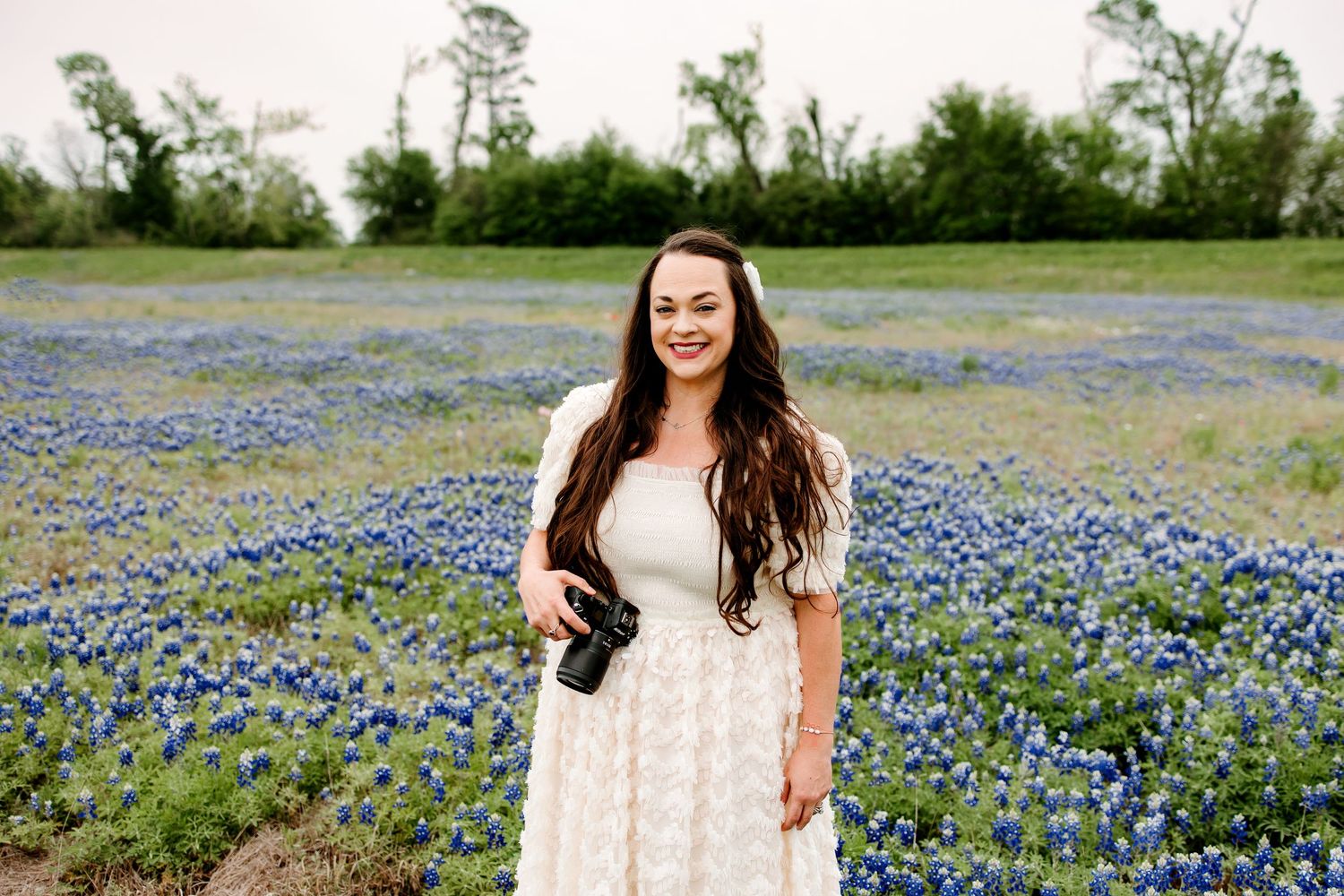 Spring portrait session in field of purple bluebonnets during golden hour.
