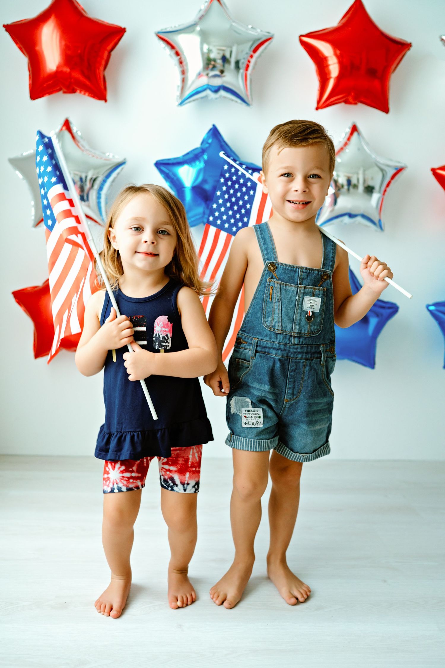 Patriotic decorations with red and blue star balloons and American flags create a festive July 4th celebration backdrop.