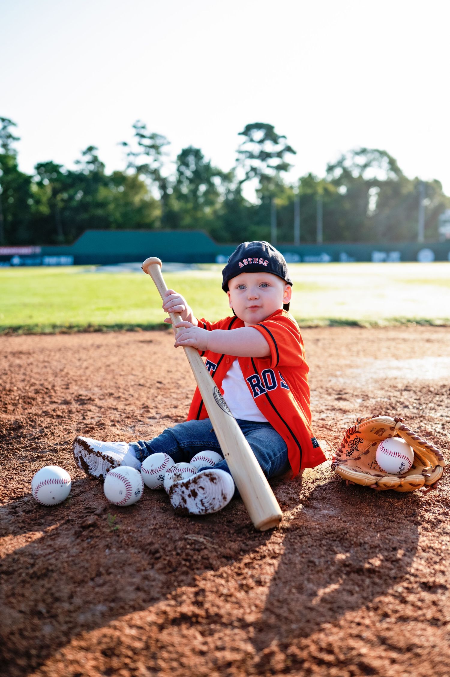 A sequence showing a small baseball player sliding on red dirt with baseballs and a bat.