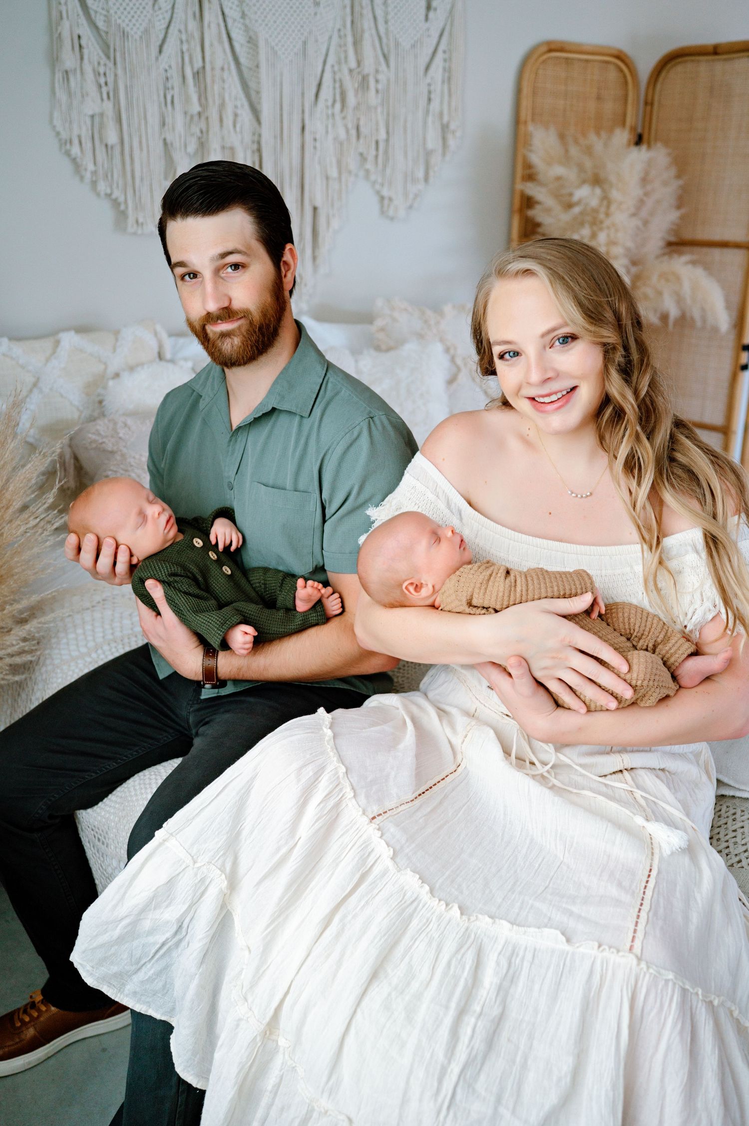 Tender moment captured of a family in soft white and green tones during a baptism celebration photoshoot.