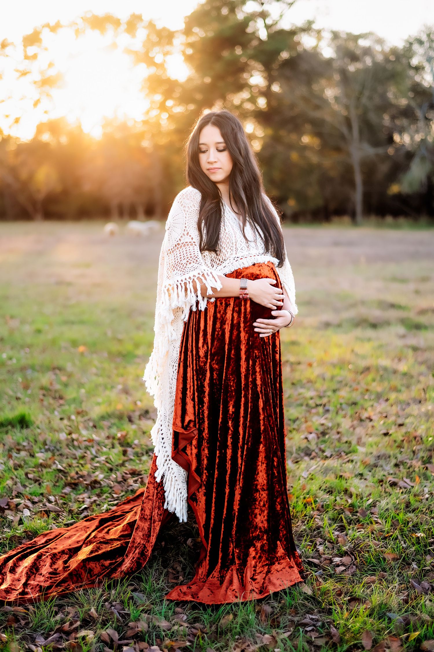 Sunset maternity photo in white crochet shawl and burgundy velvet dress.