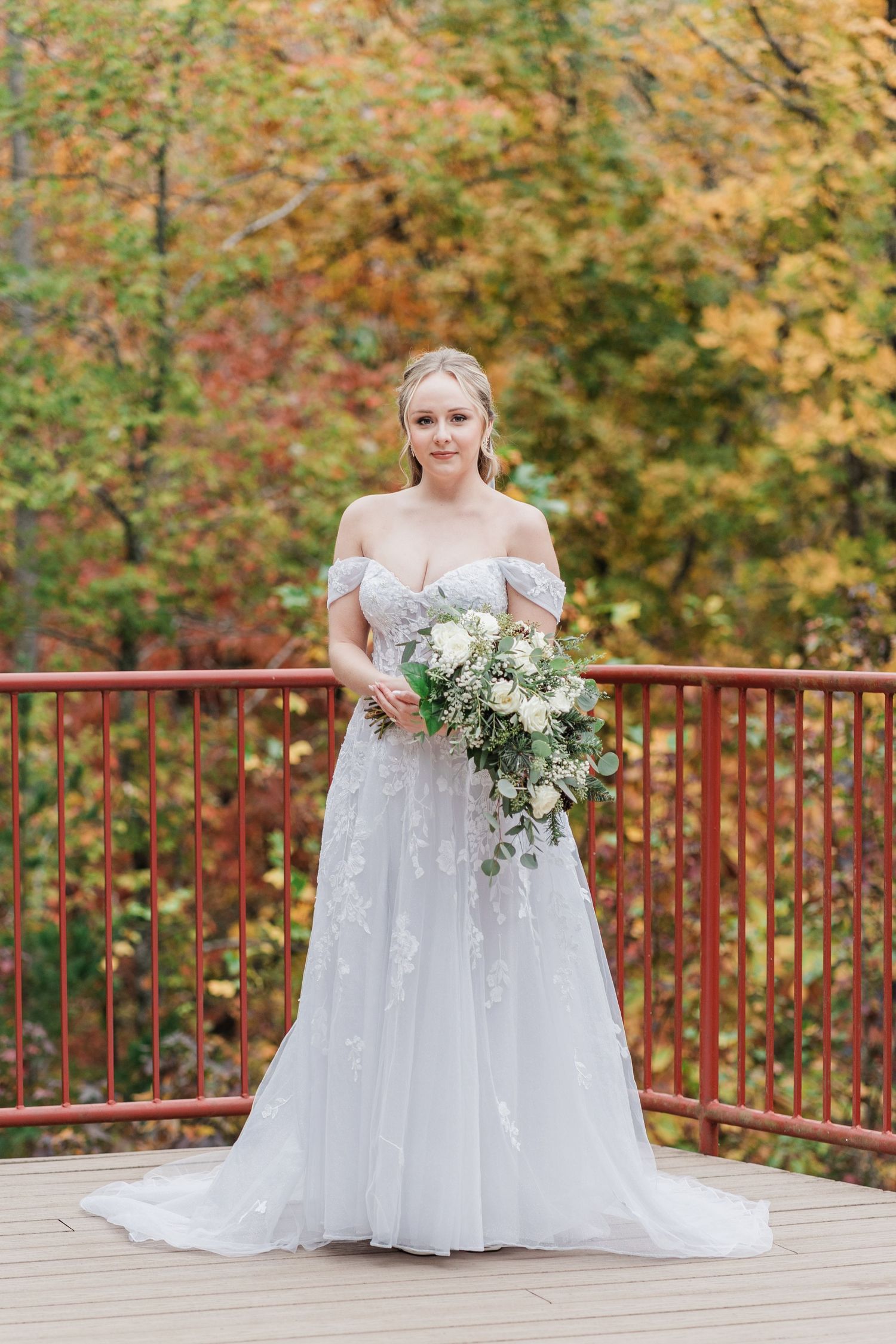 bride in her gown in front of vibrant fall foliage