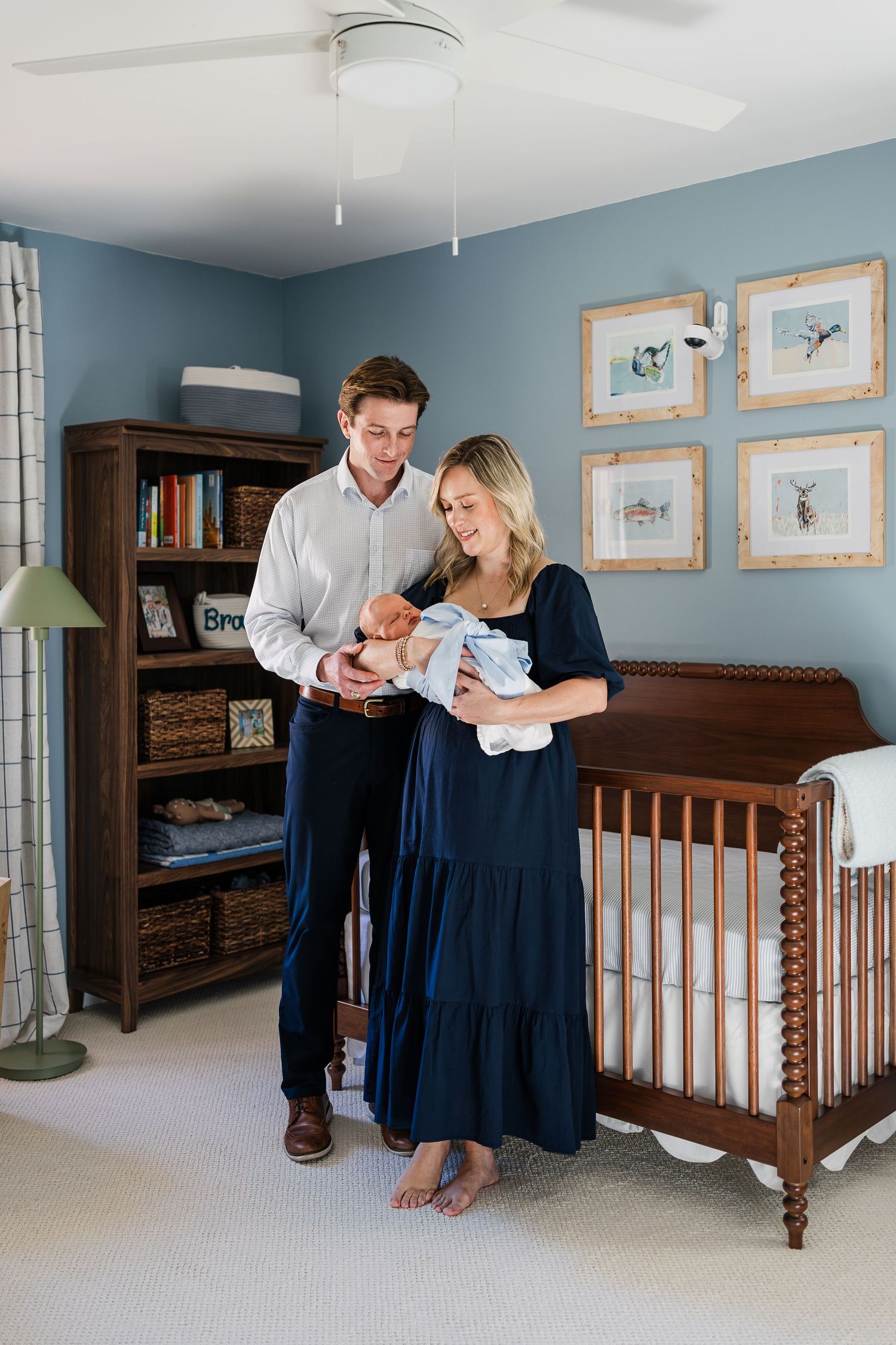 First time parents smiling at newborn during natural light session in their Greenville SC home.