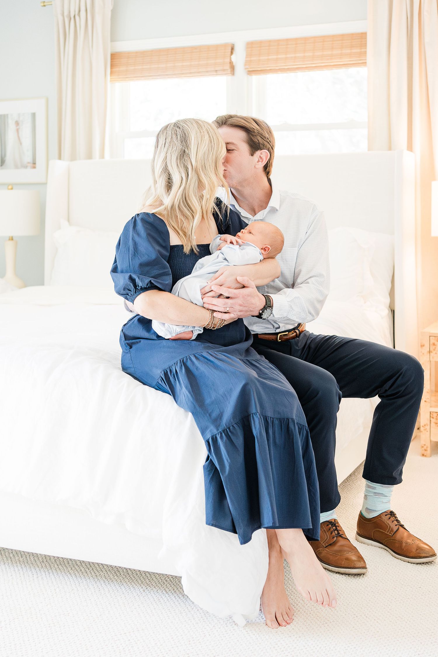 Laney cradling Bradham in her arms while sharing a kiss with Chandler surrounded by natural light from their large bedroom windows