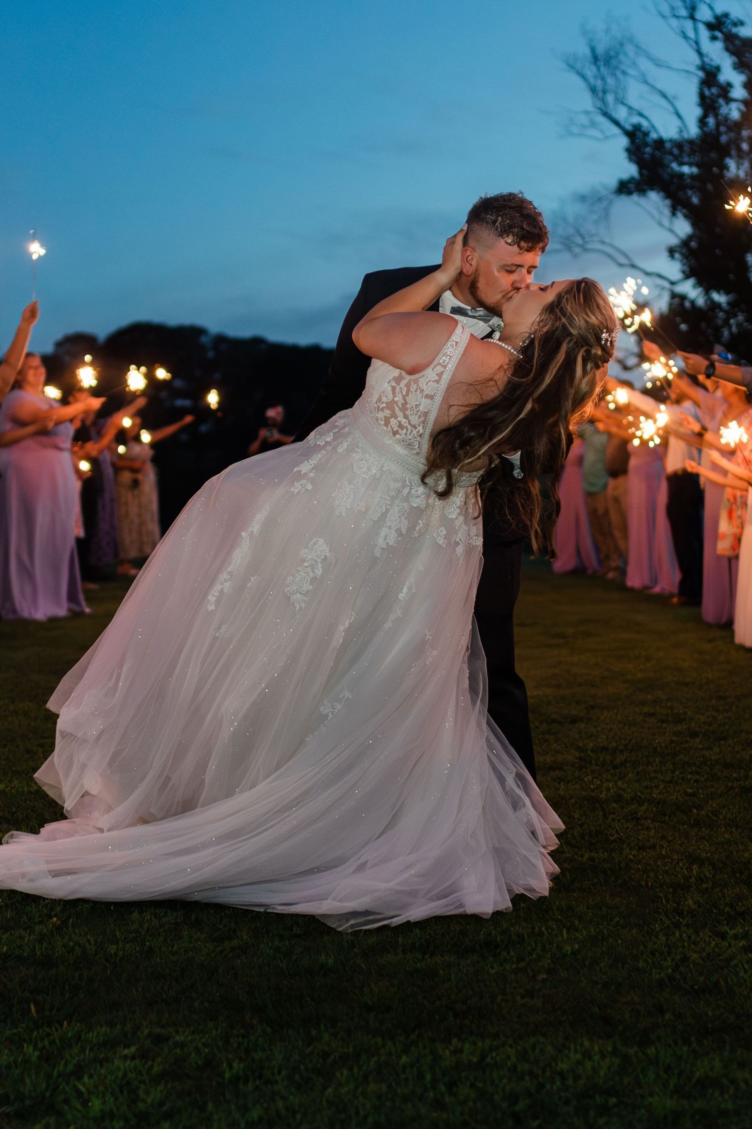 groom dipping bride into a kiss during the sparkler send off