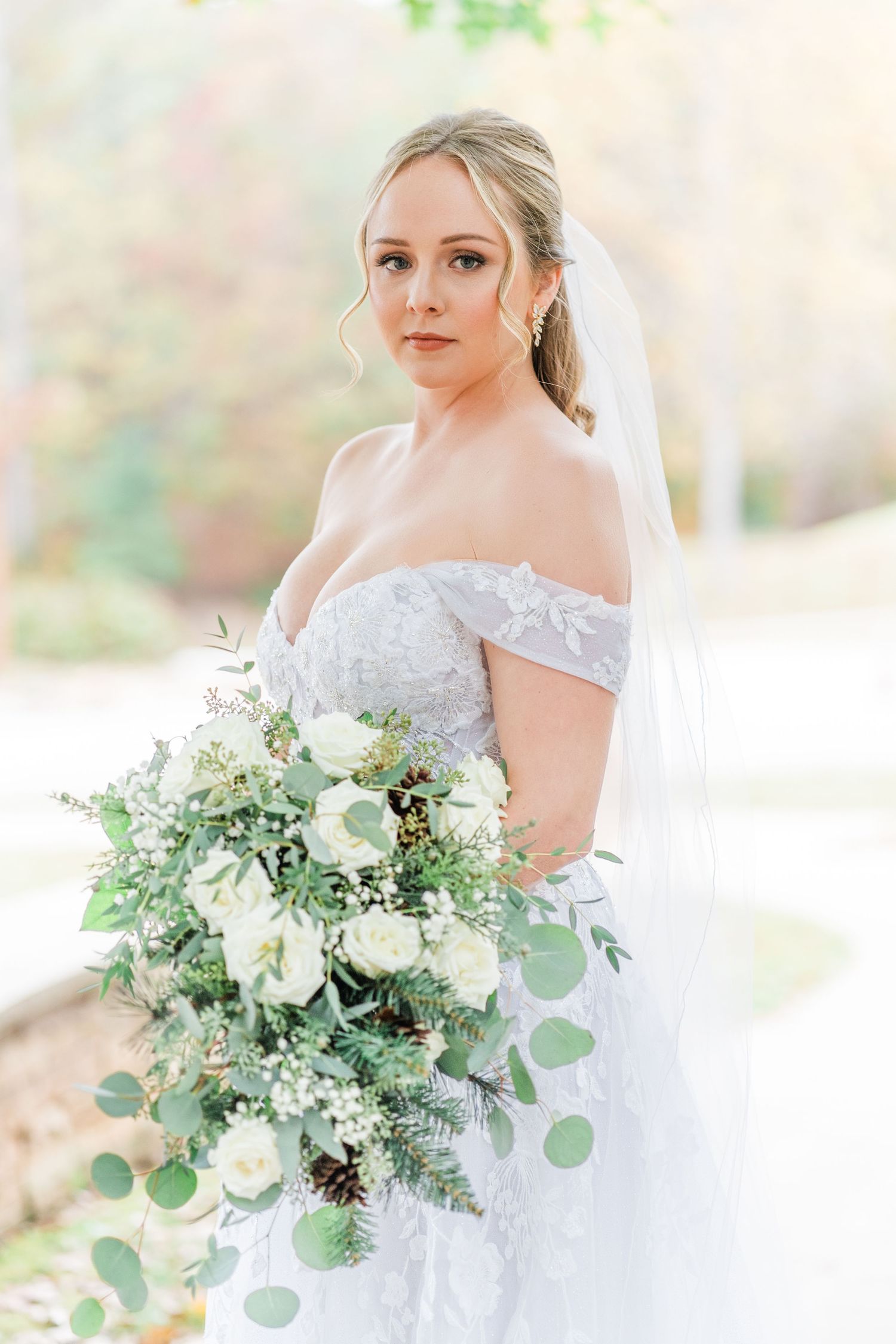 bride in gown holding her cascading bouquet of flowers