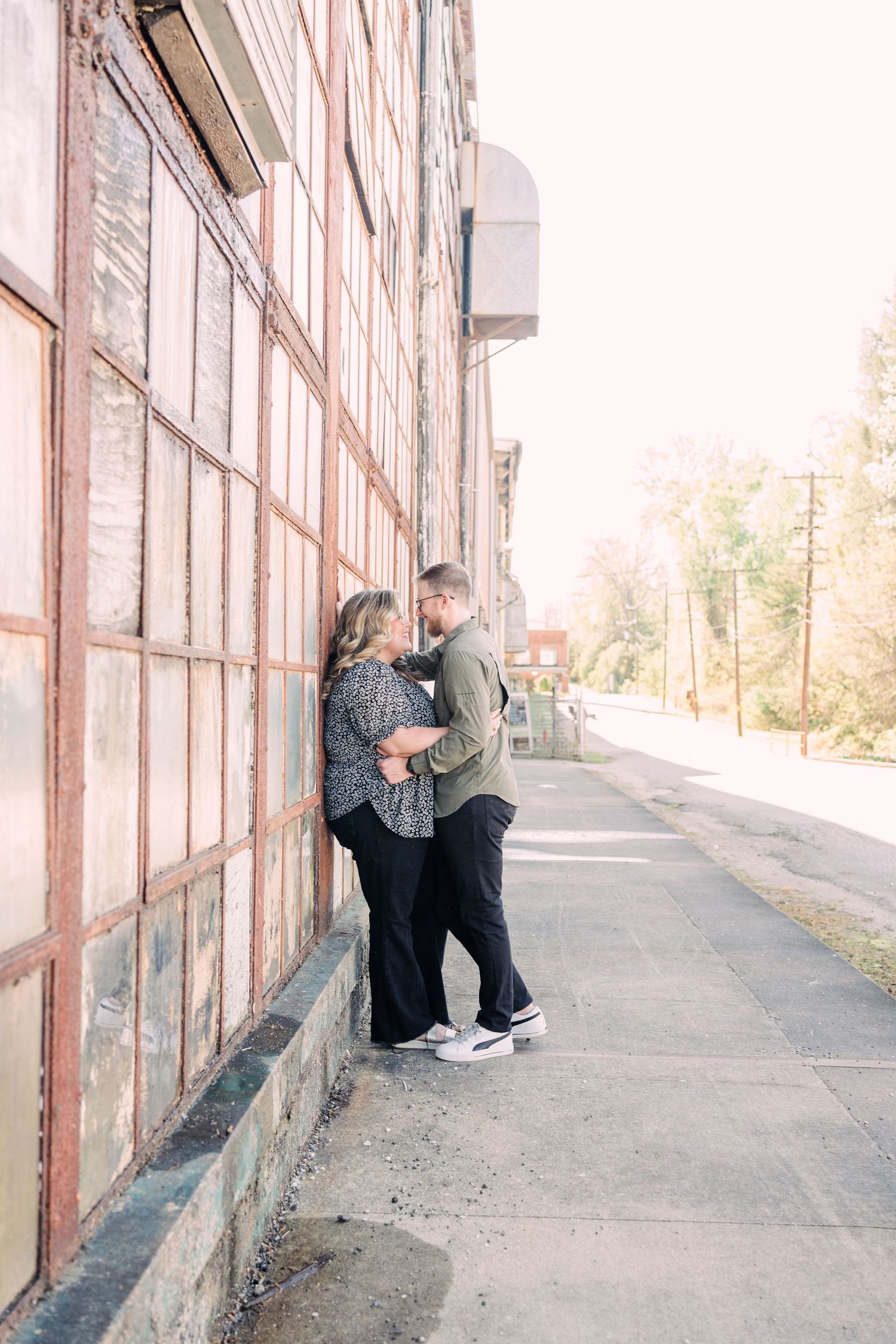 Man and woman leaning against the windows at Taylors Mill gazing into each other's eyes.