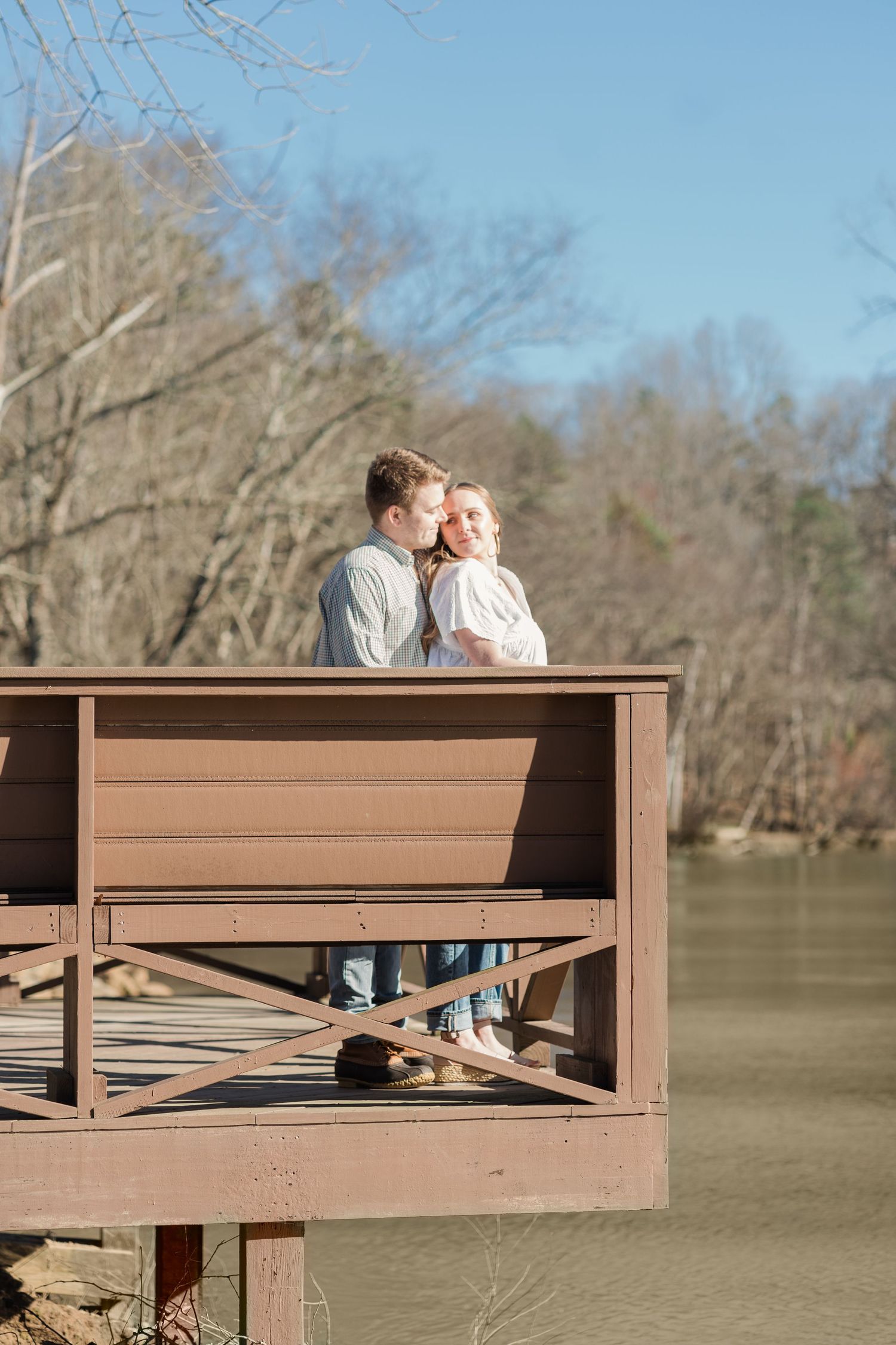 Man and woman standing close together on a deck overlooking the Saluda river