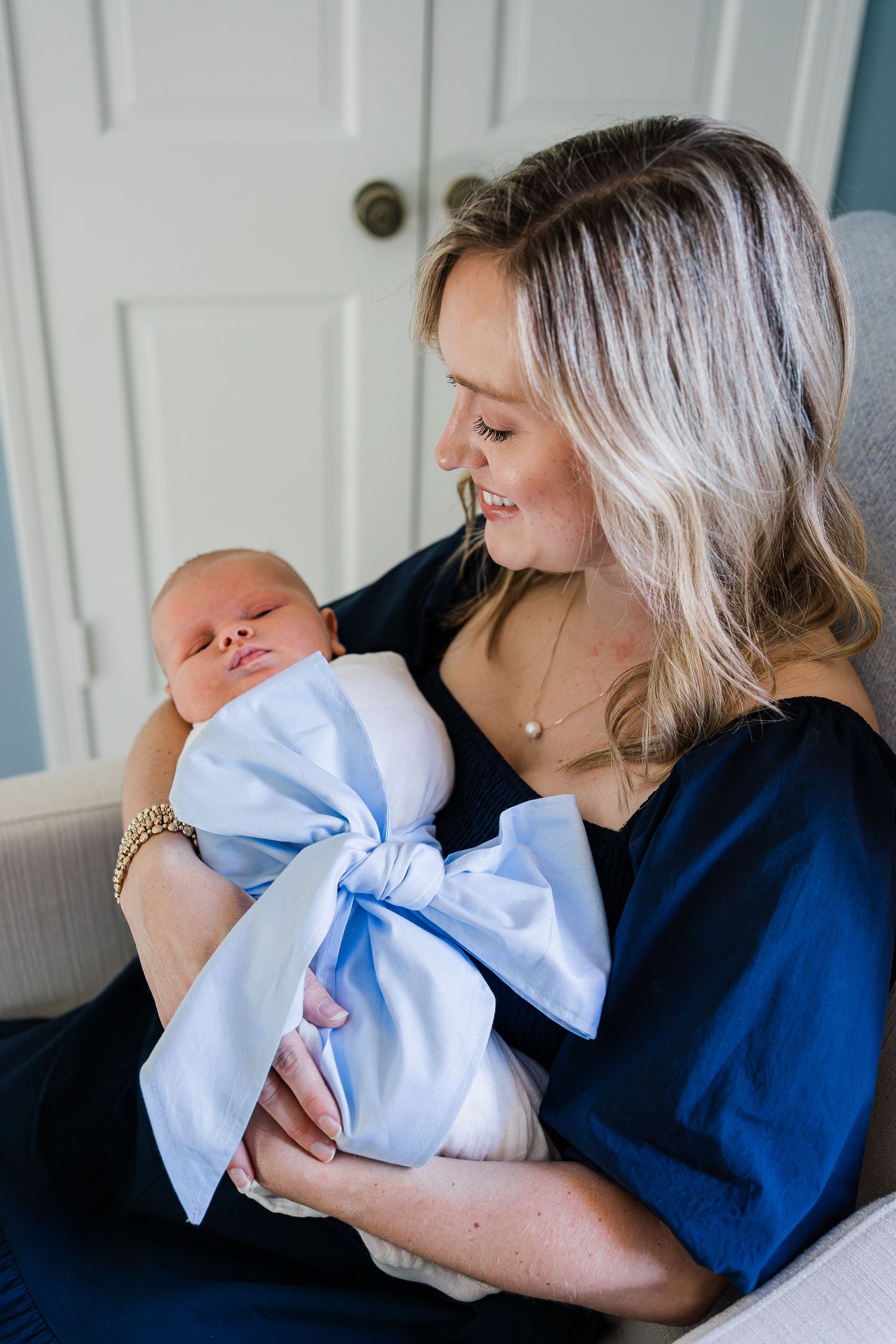 Laney smiling down at Bradham in her arms in his nursery