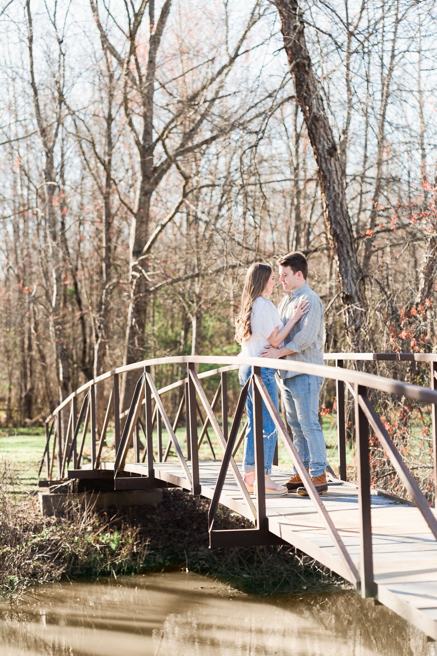 Couple facing each other on a wooden bridge over the Saluda River