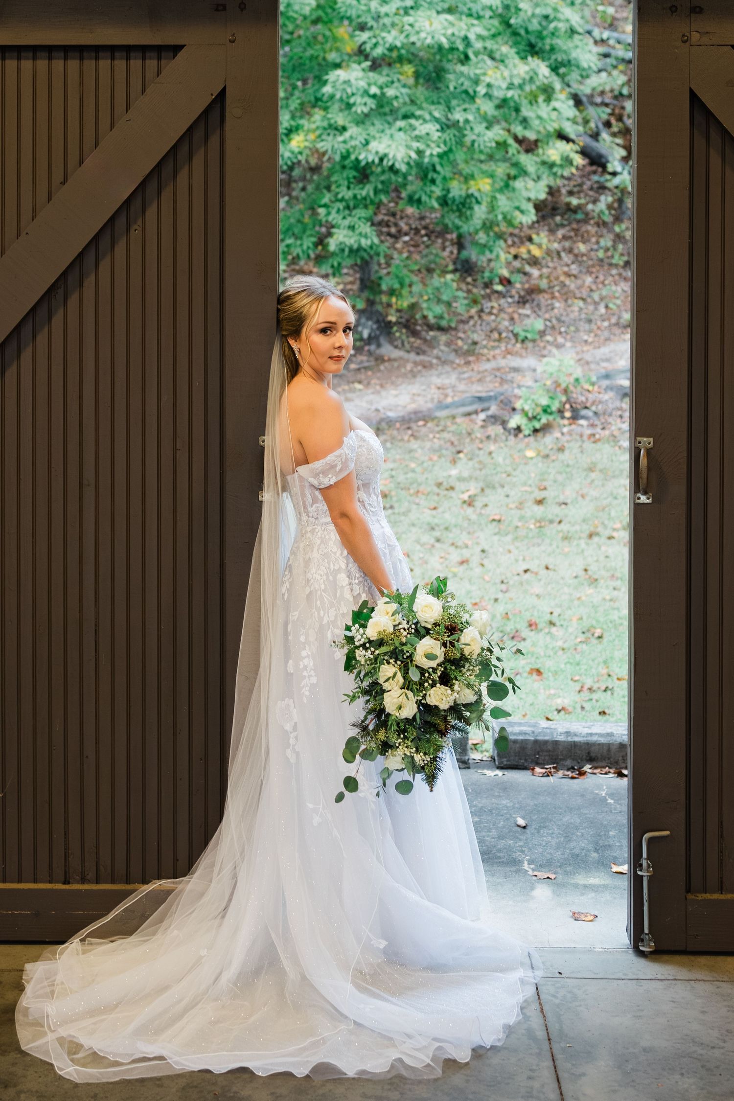 bride leaning against sliding doors of one of the amphitheatre at camp spearhead