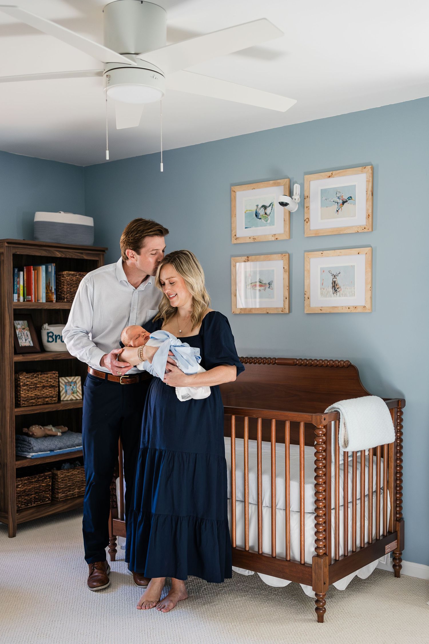 Mother and father holding baby Bradham in his nursery with natural light surrounding them