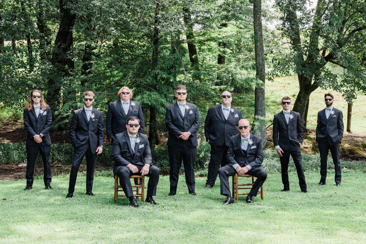 the groom and his groomsmen in a grove of trees