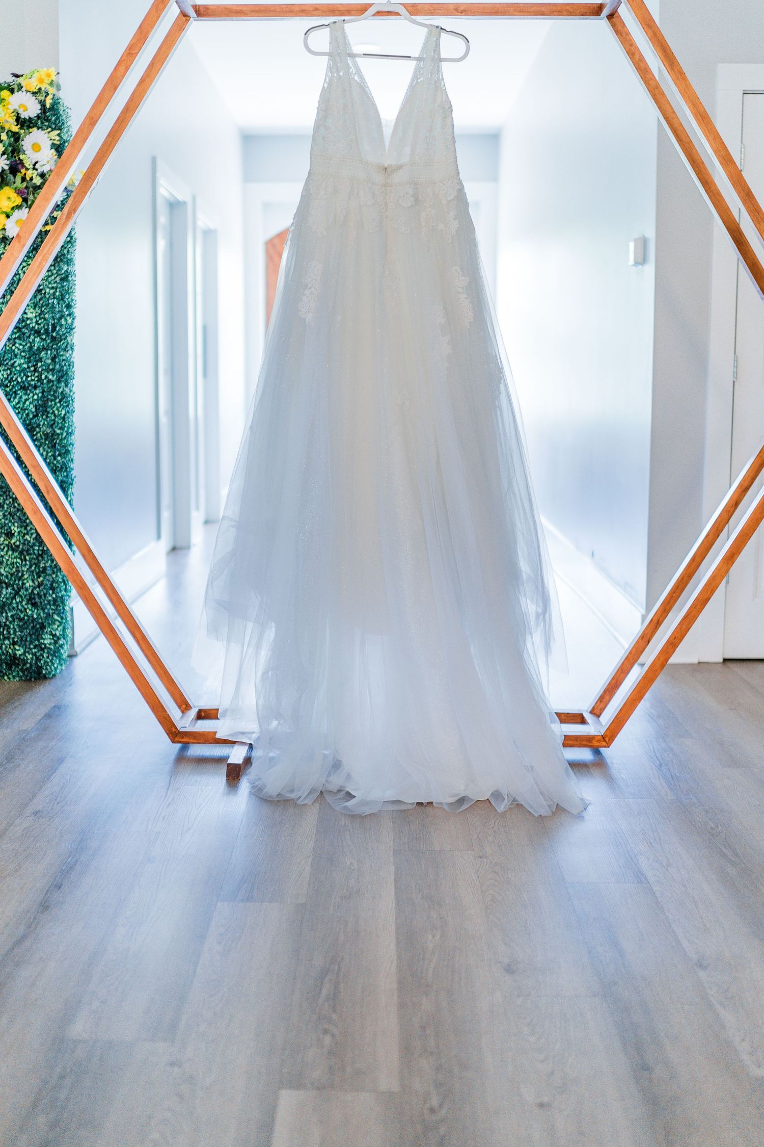wedding dress hanging from a wooden arbor