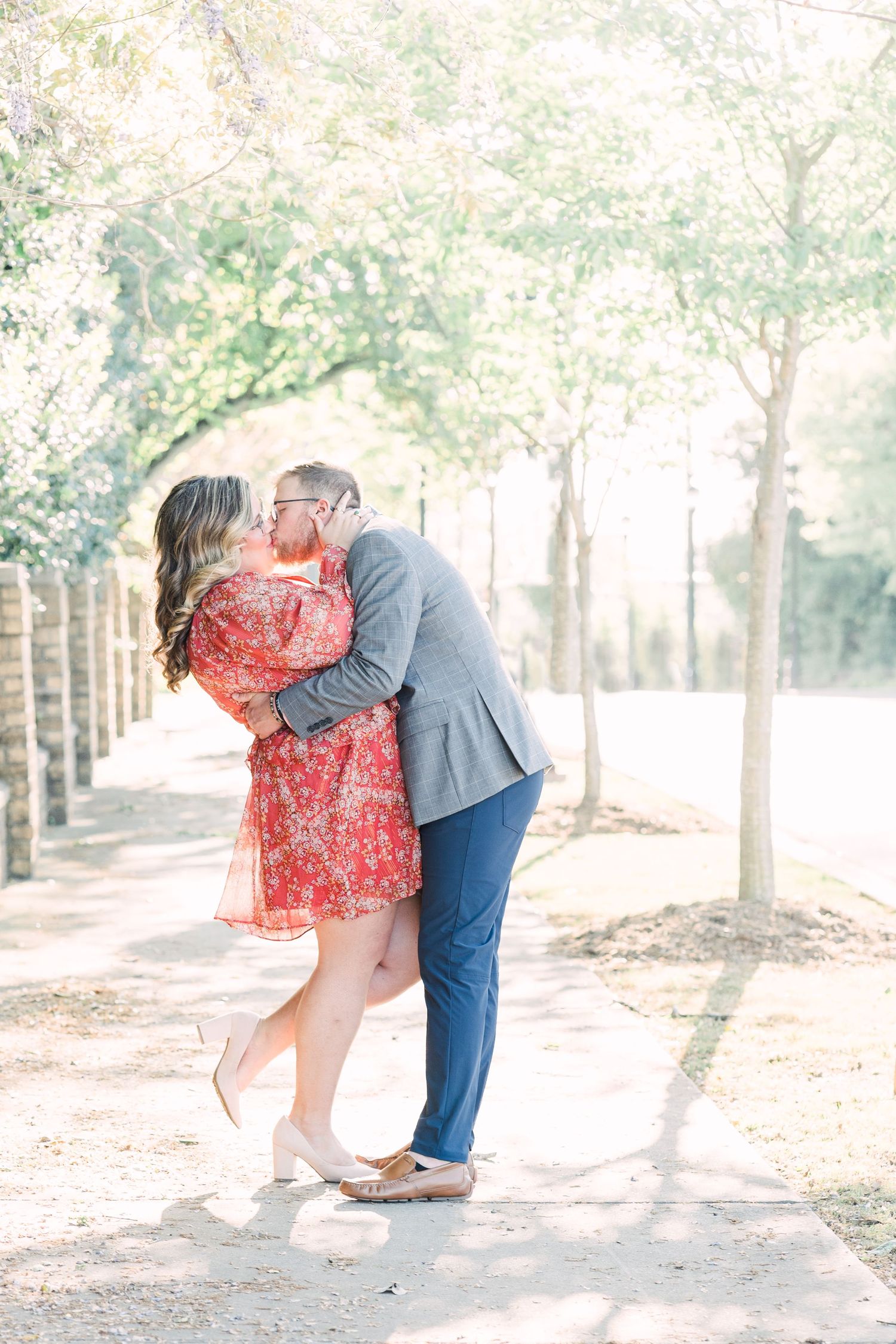 Couple kissing on sidewalk in downtown Greer