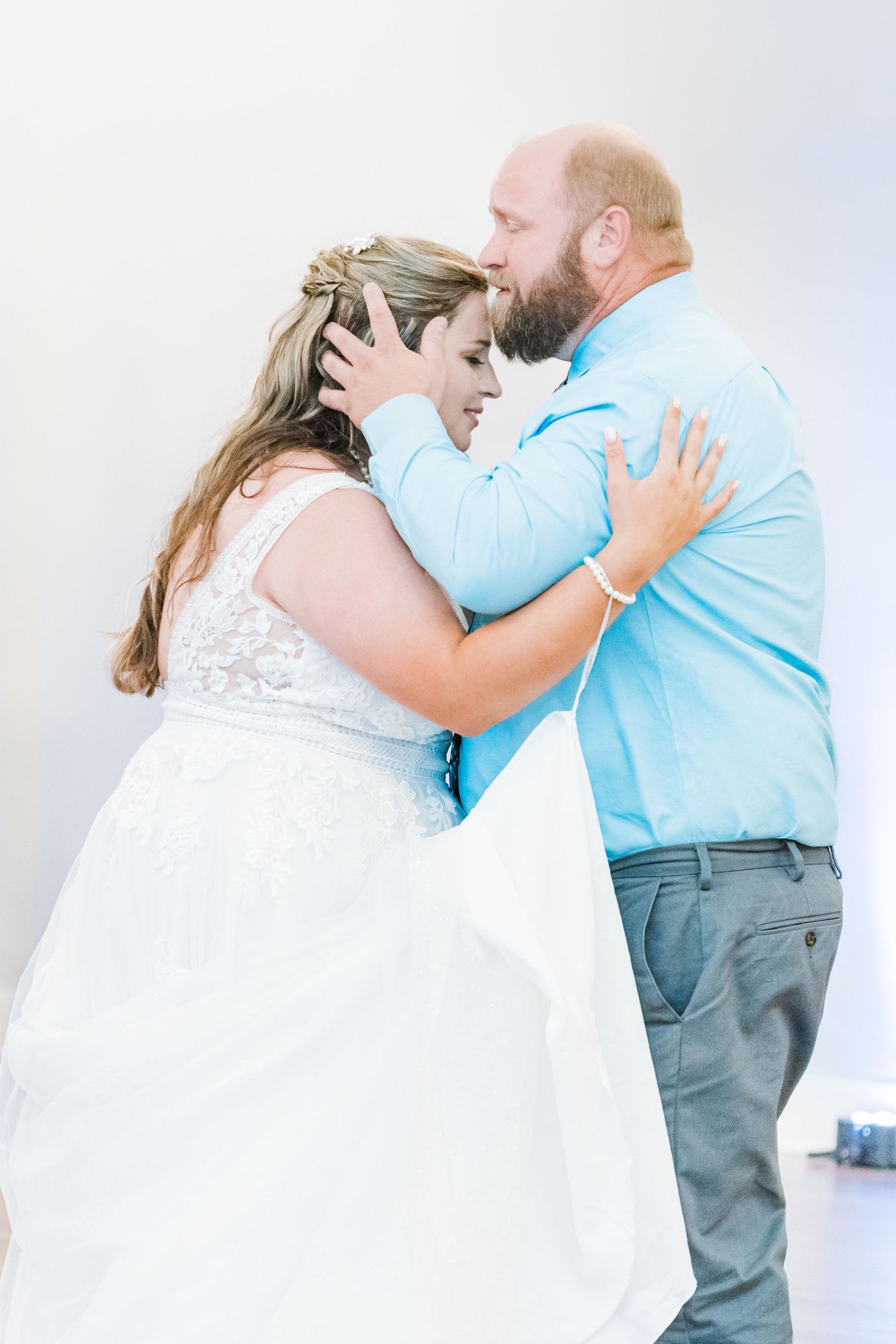friend kissing bride on forehead during special father/daughter dance