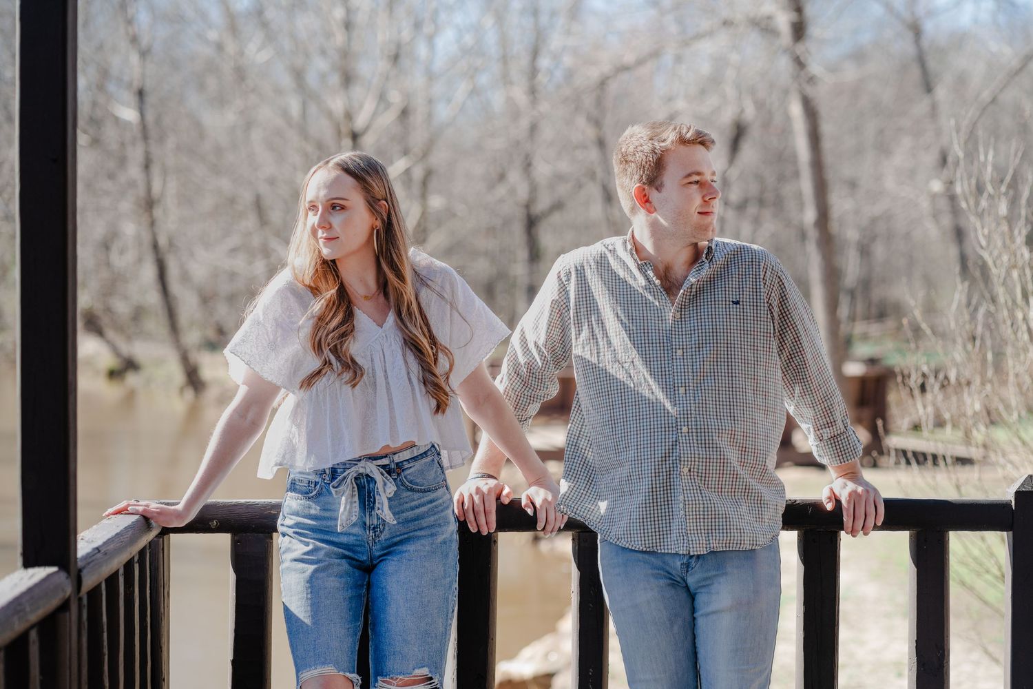Couple looking away from each other while leaning against the railing of a cabin by the Saluda river