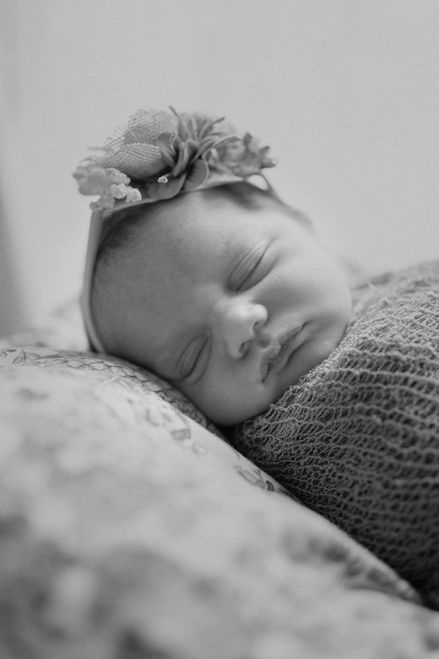 Newborn girl in basket set up with pink blanket and bow during in in-home portrait session