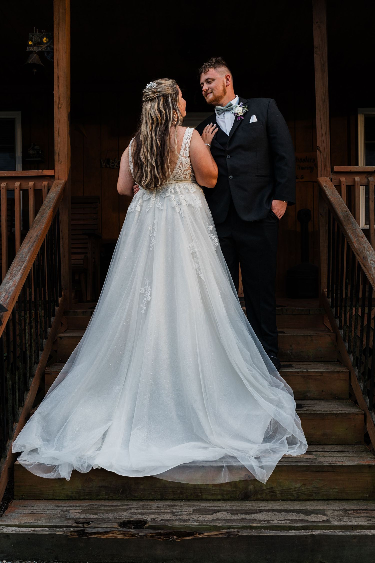bride and groom facing each other on cabin stairs