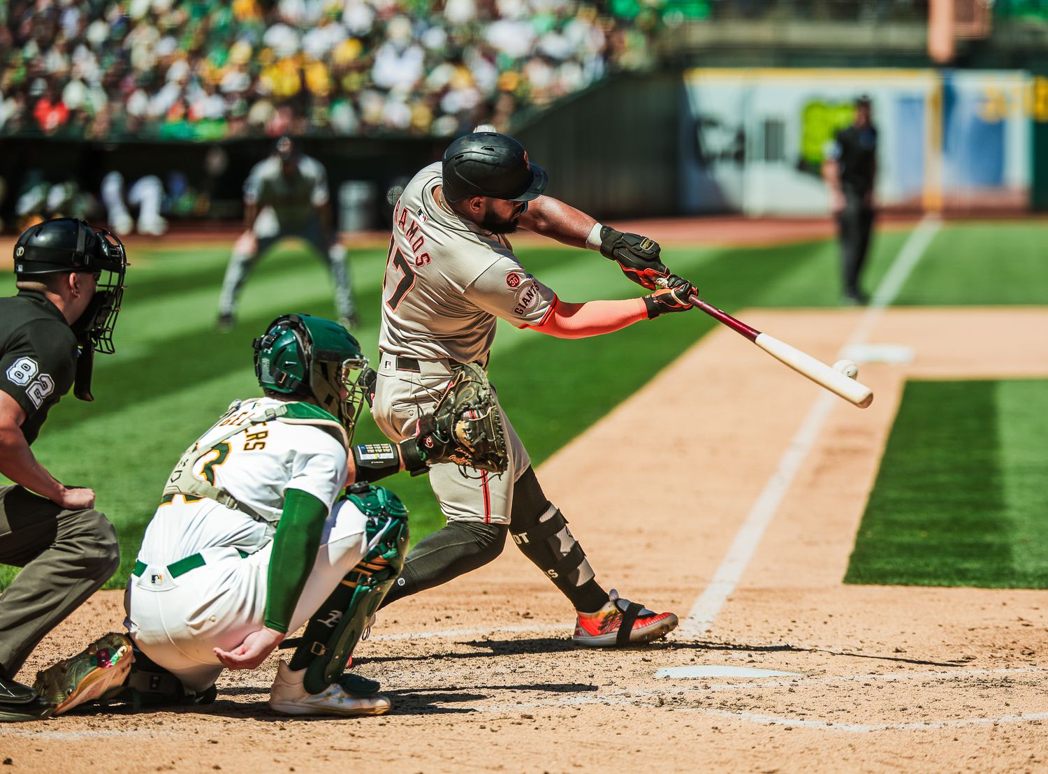 Baseball player swinging bat during a professional game with catcher and umpire in frame.