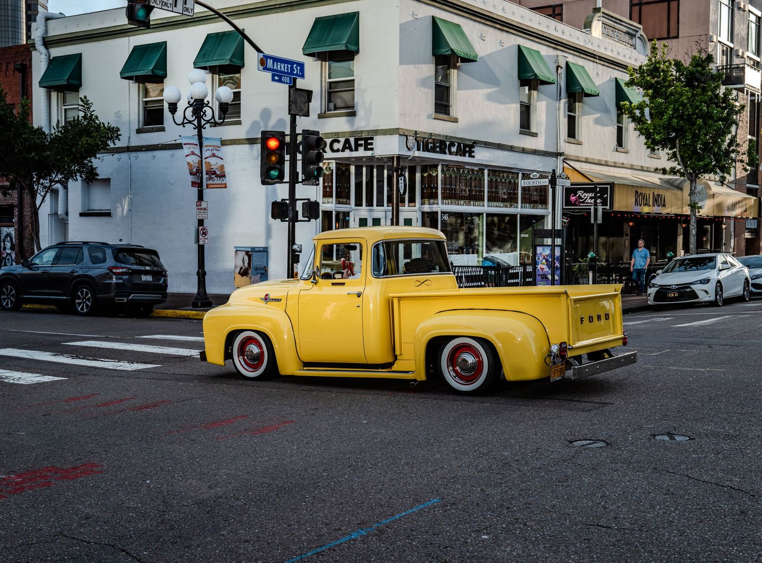 Vintage yellow taxi parked on urban street corner.