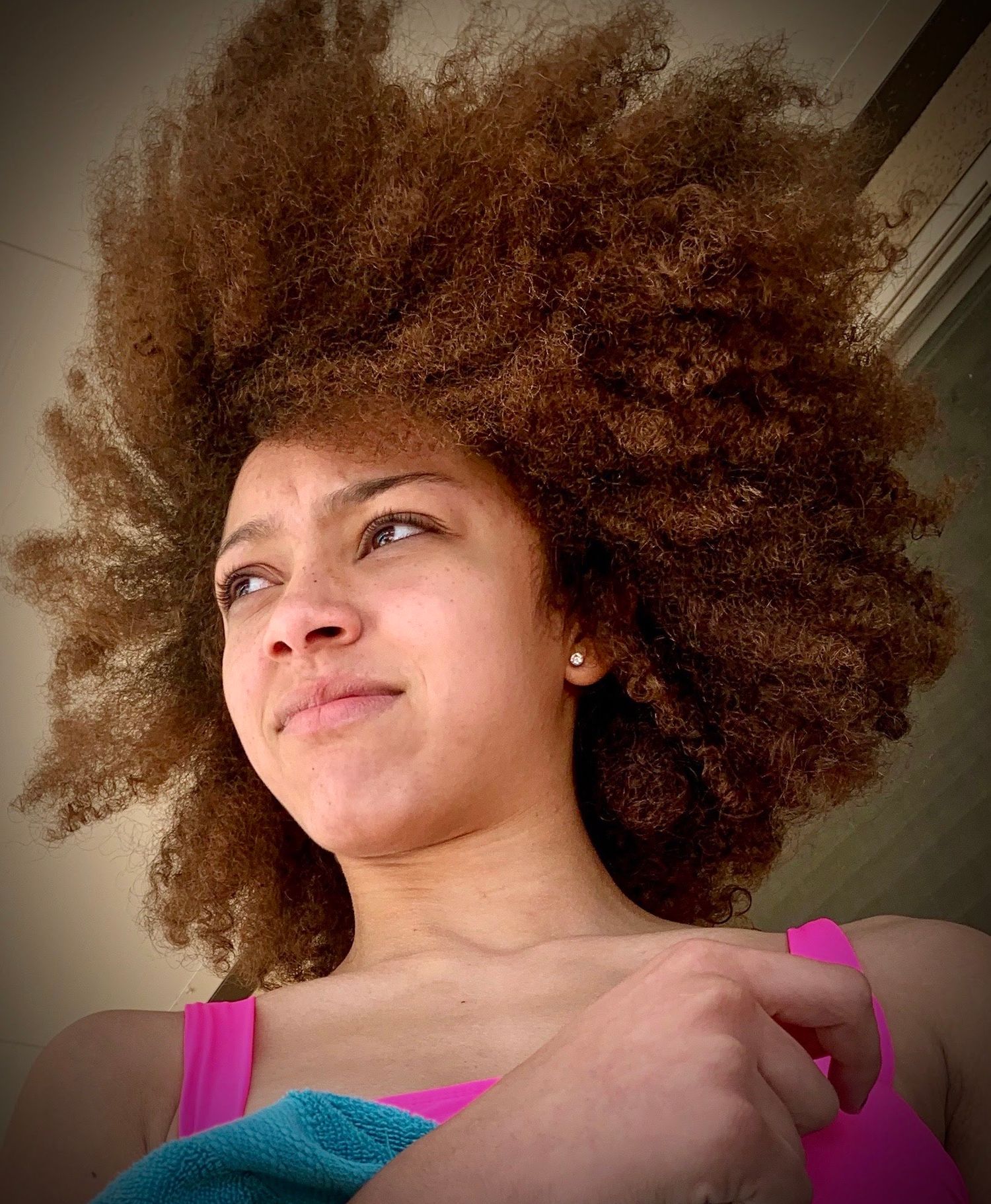 Natural curly afro hair captured in artistic selfie series with warm lighting.