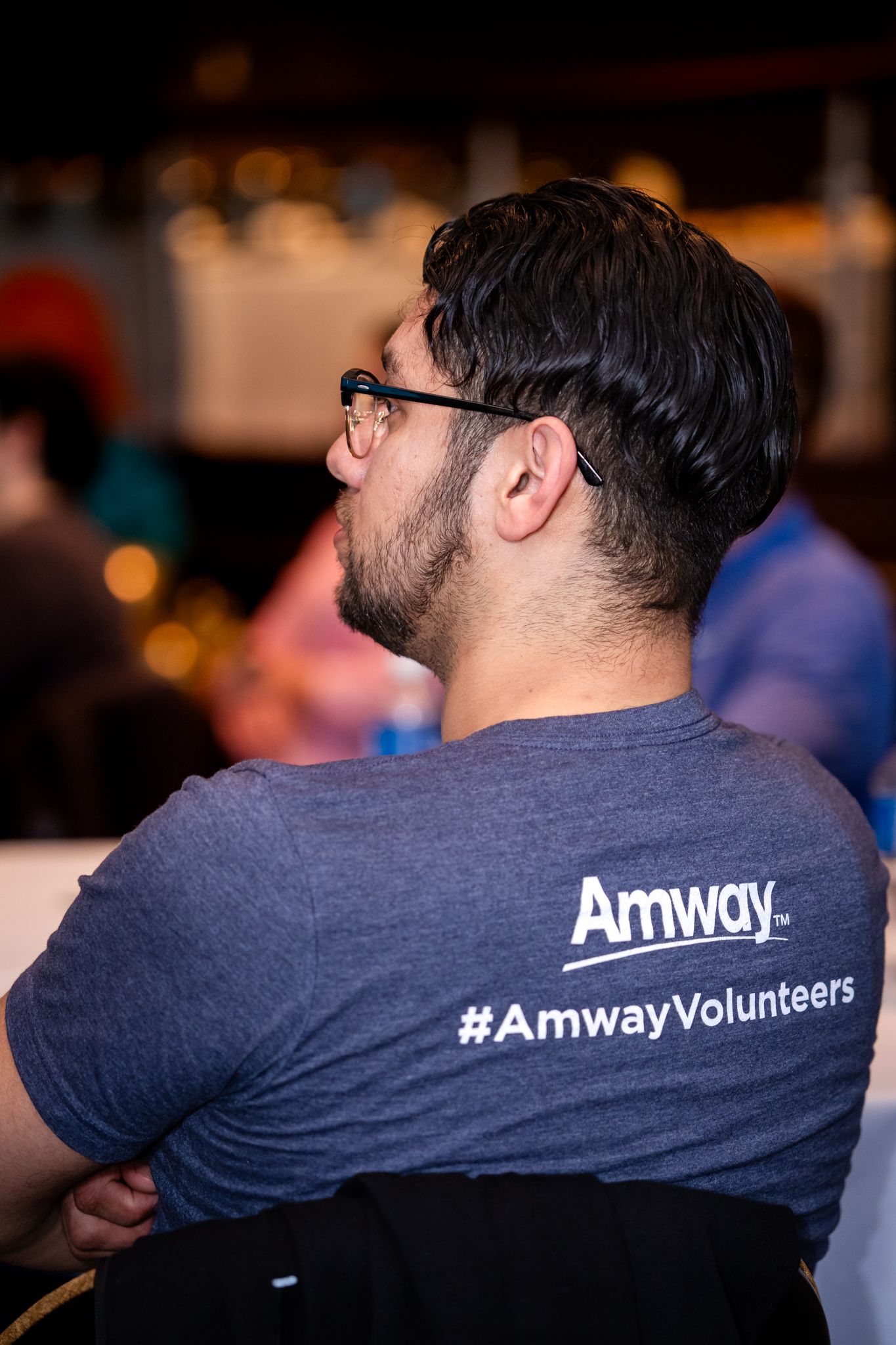 Man wearing Amway Volunteers t-shirt attending the GROW Finale Celebration corporate event.