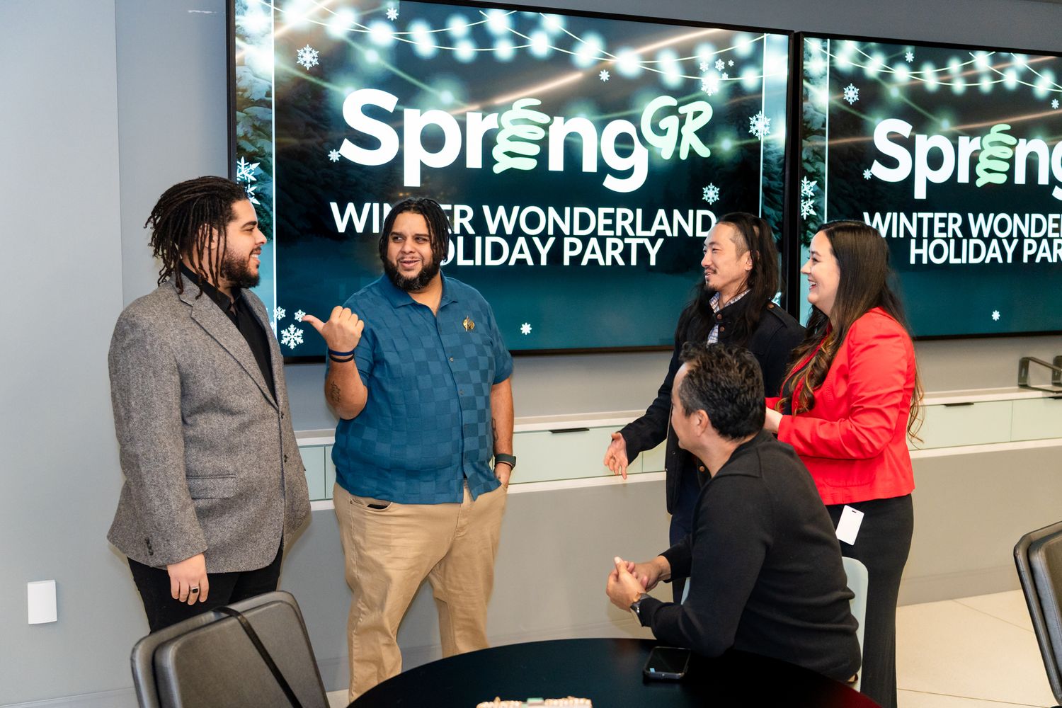 Group of professionals networking at a SpringGR Winter Wonderland Holiday Party event.