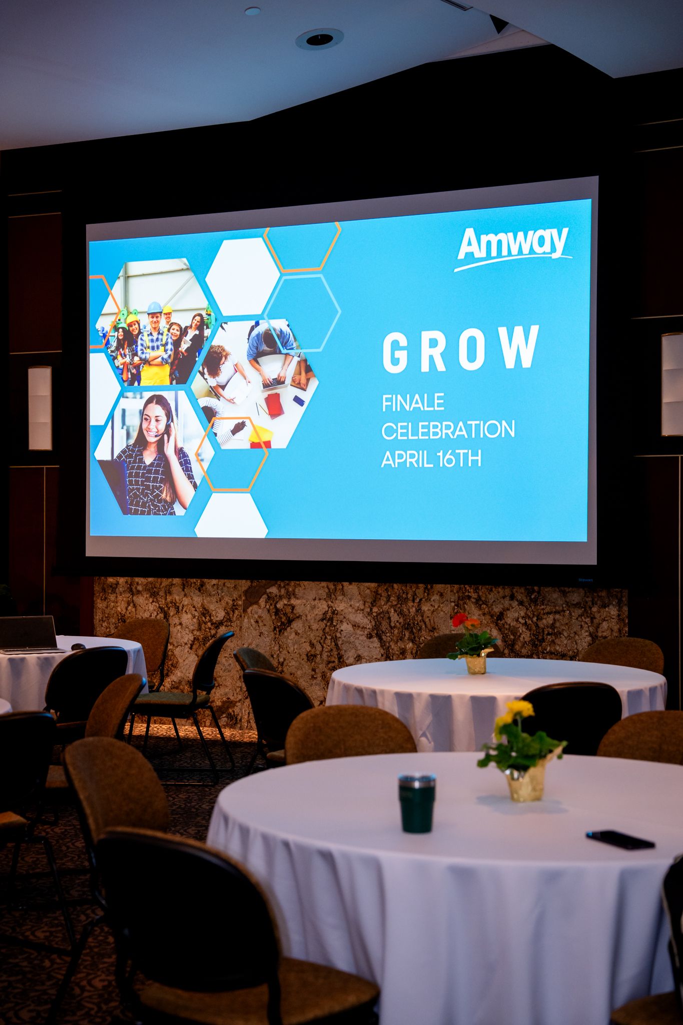 Amway GROW Finale Celebration April 16th presentation slide displayed on a large screen in a banquet room.