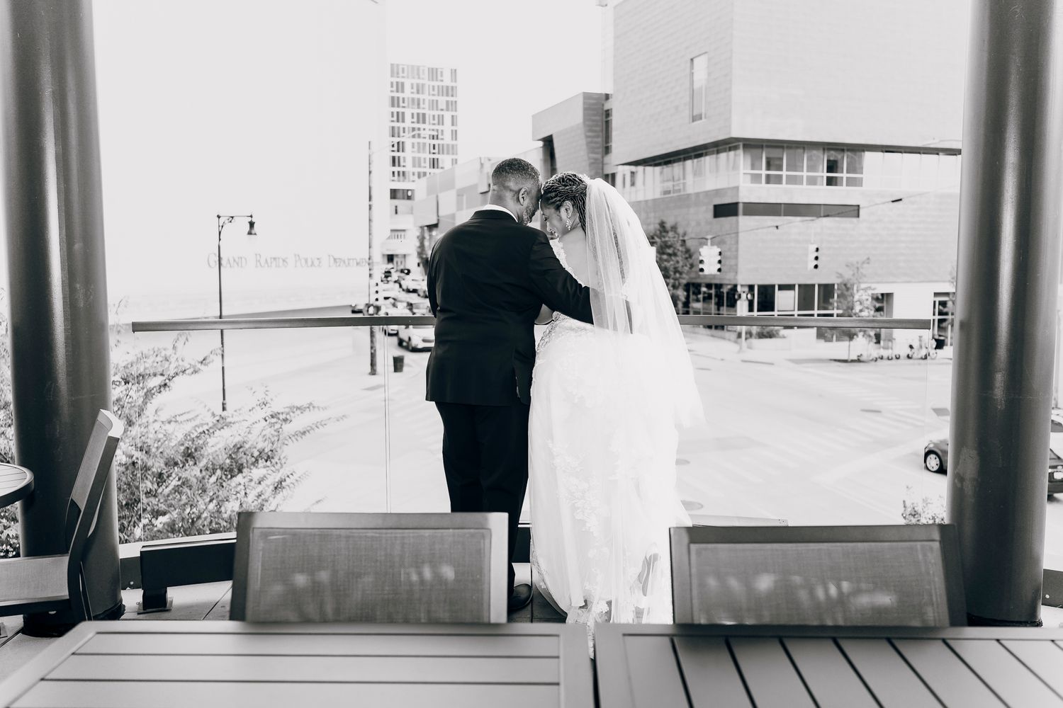Bride and groom share an intimate moment on an outdoor deck in black and white photo.
