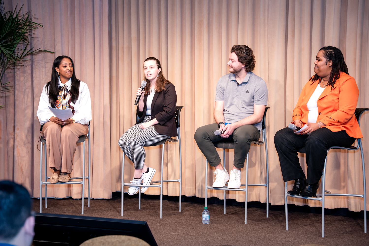 Four panelists seated on stools during a discussion panel at the Amway GROW Finale Celebration event.