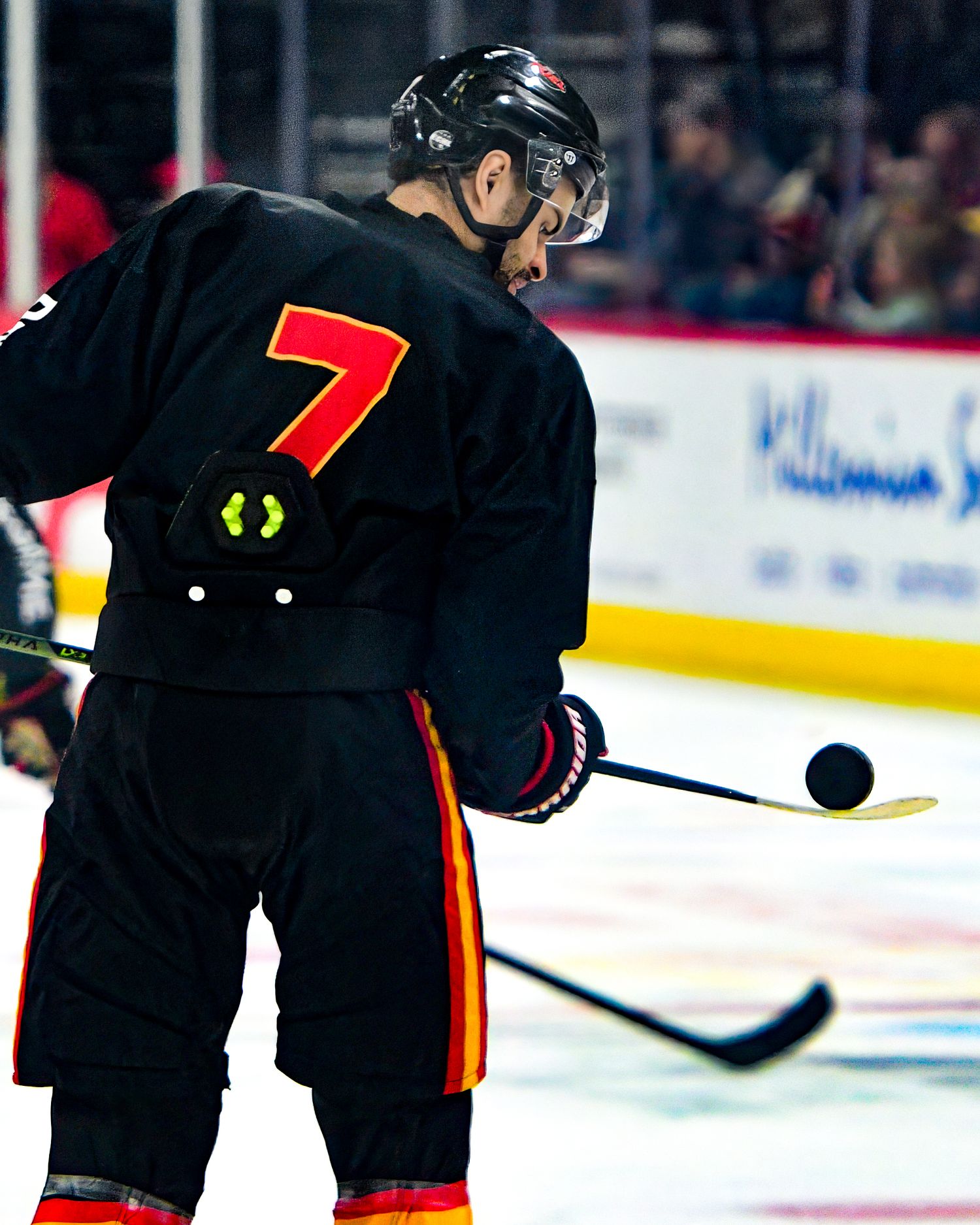 Professional minor league hockey player balancing a puck on his hockey stick