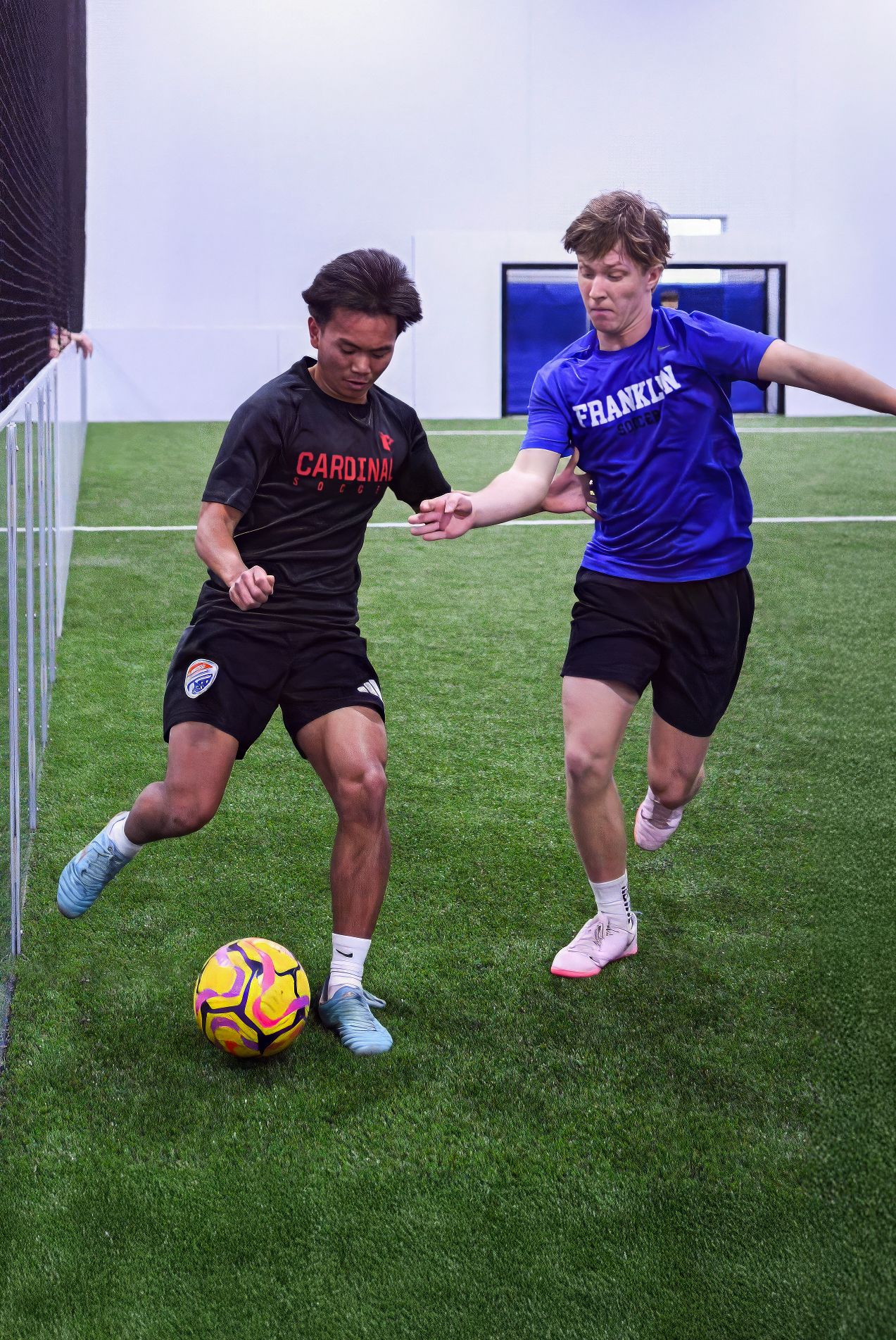 College males playing indoor soccer