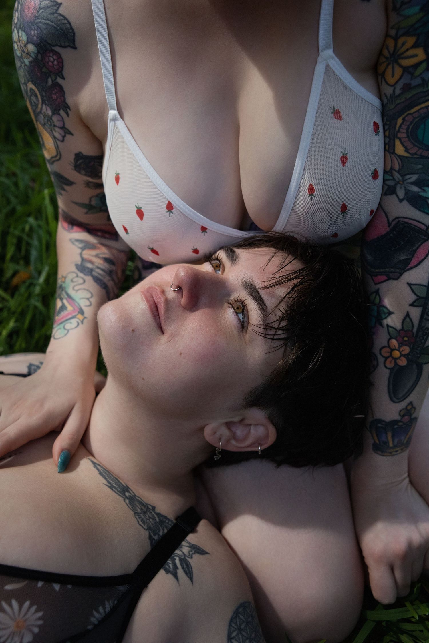 Portrait showing tattoos and white lingerie against natural backdrop.