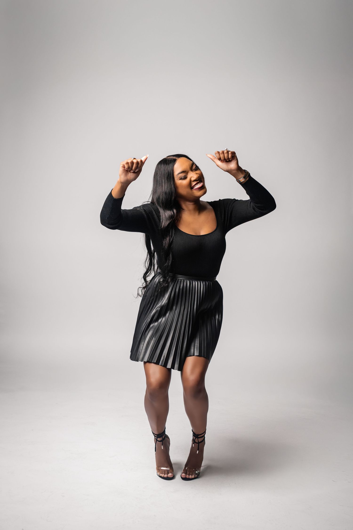 Artistic photo series showing dynamic dance poses in a little black dress against a light gray studio backdrop.